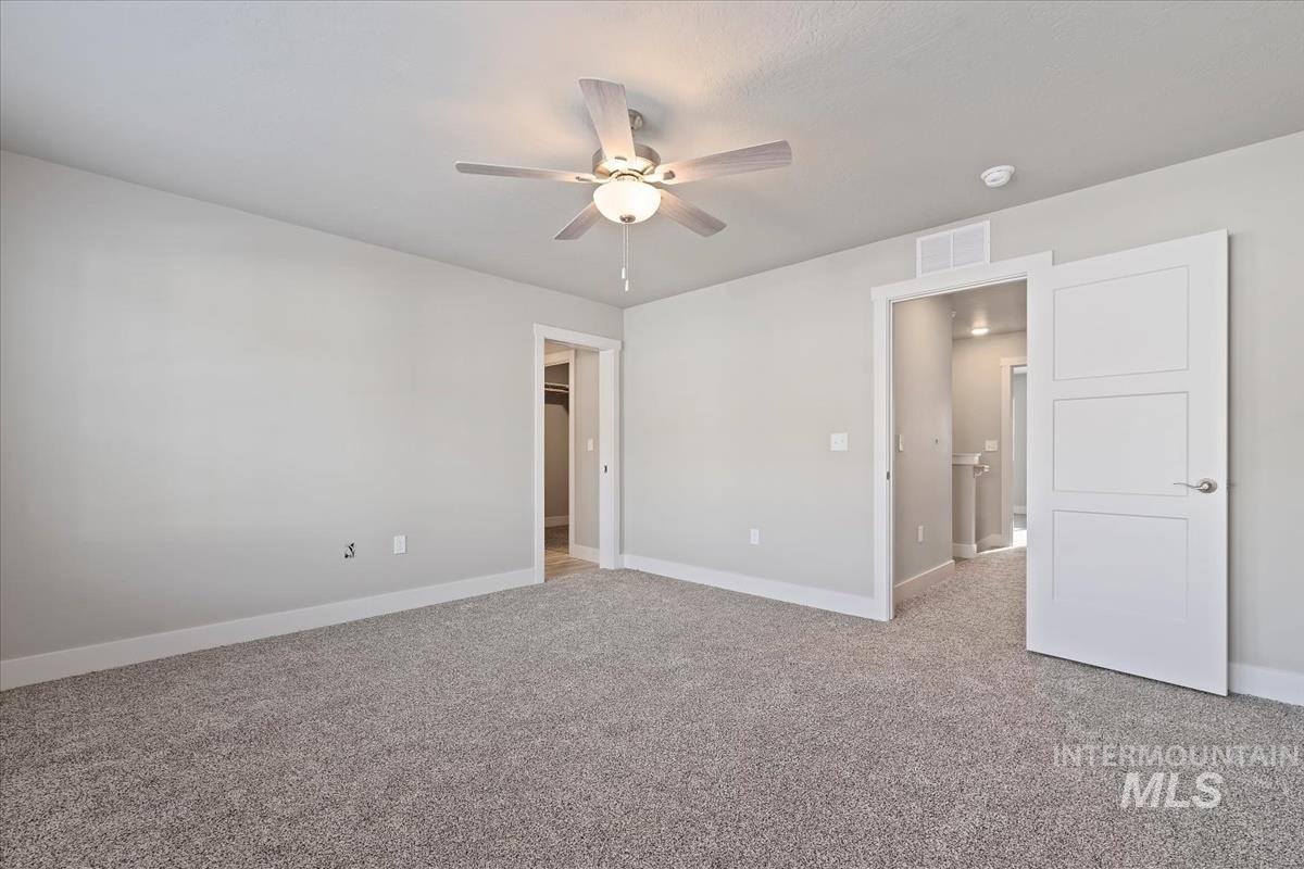 Unfurnished bedroom featuring light carpet and ceiling fan