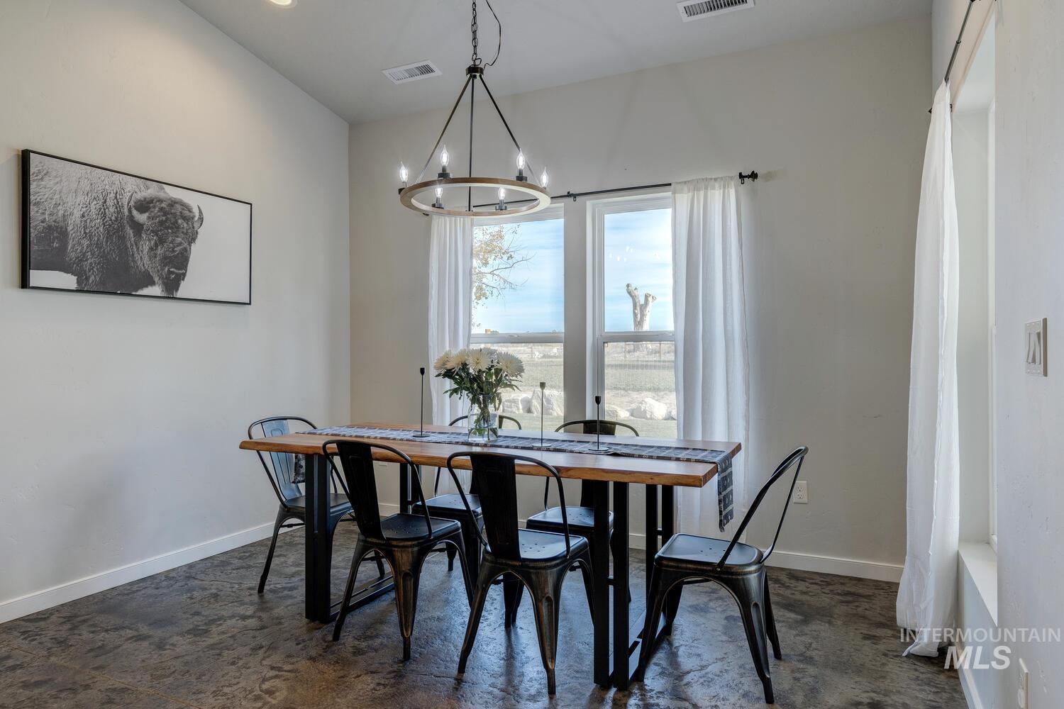 Dining area featuring baseboards and a chandelier