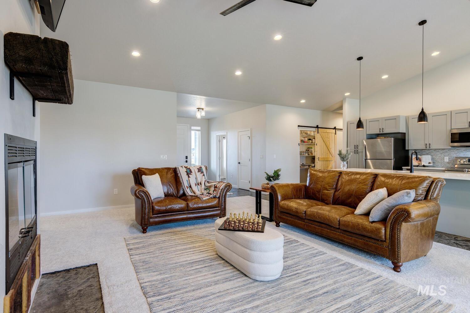 Living room with a barn door, carpet, and recessed lighting