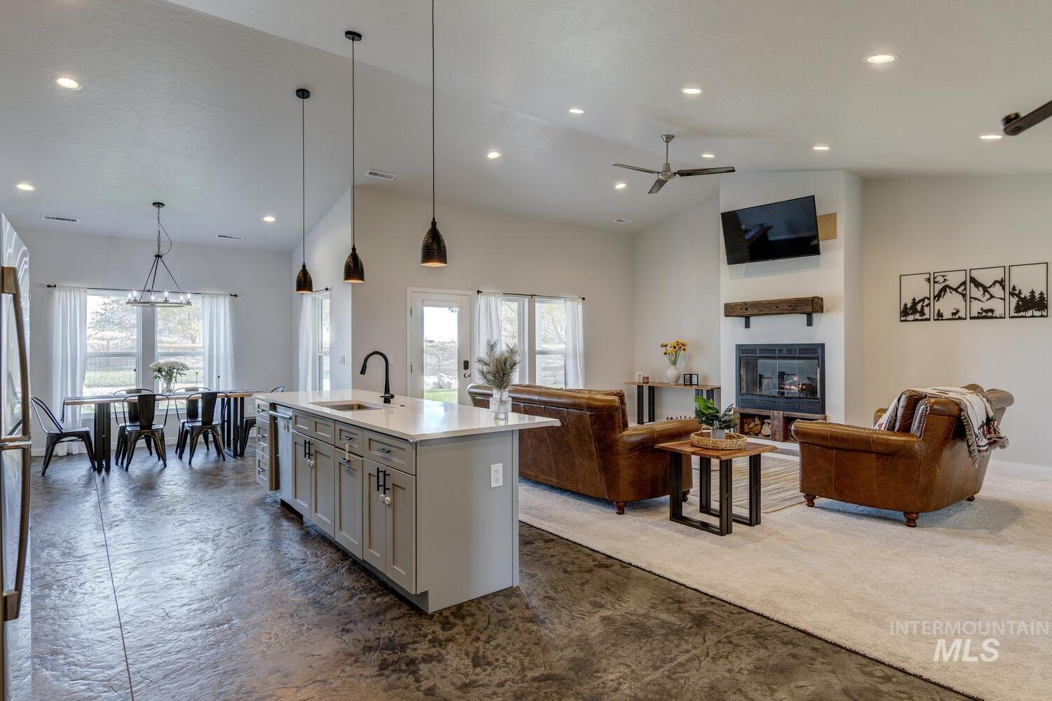 Kitchen featuring open floor plan, hanging light fixtures, a center island with sink, recessed lighting, and high vaulted ceiling