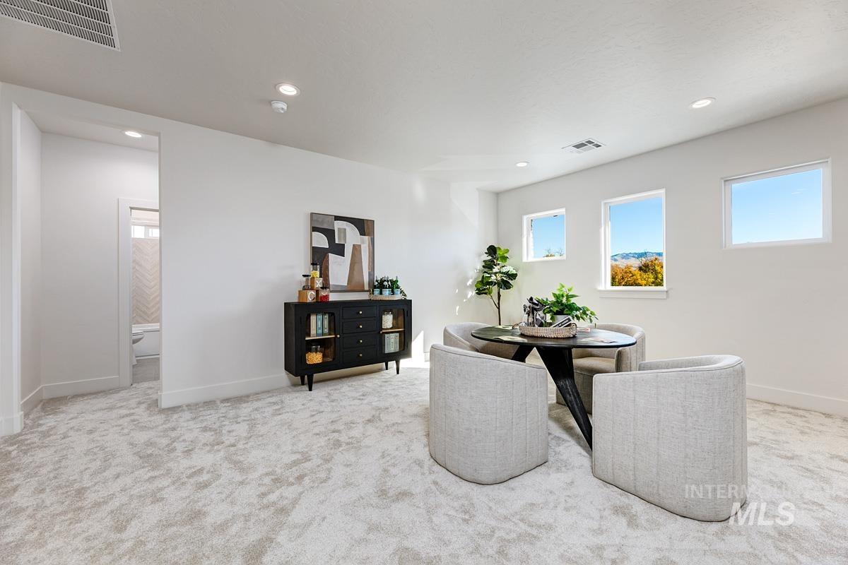 Dining room with light colored carpet and recessed lighting