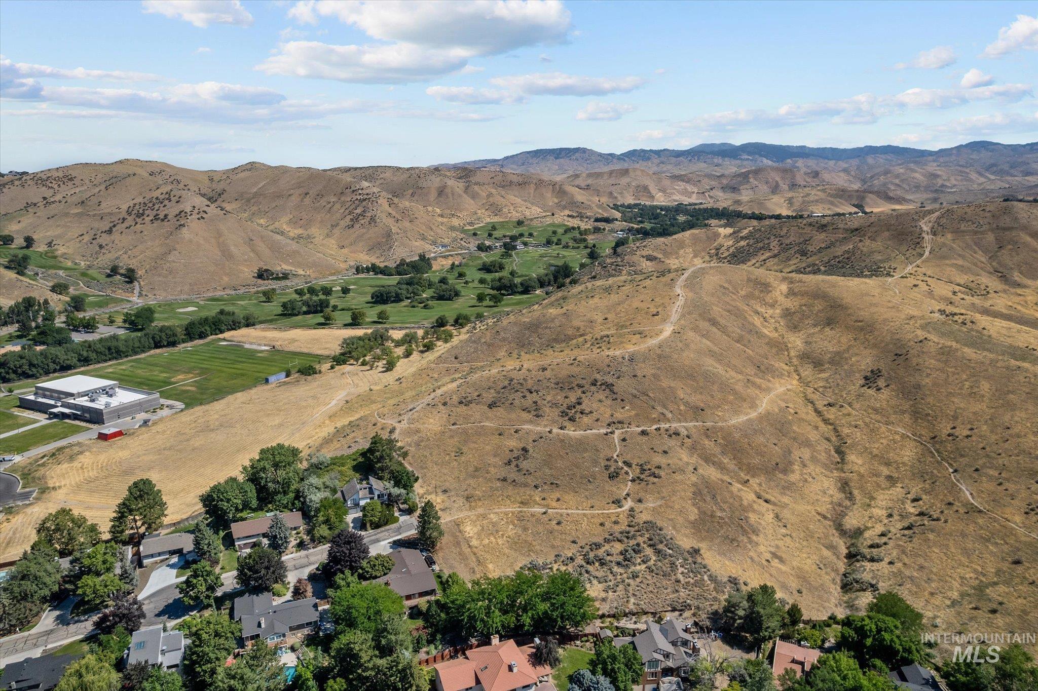 Aerial overview of property's location featuring a mountainous background and rural landscape