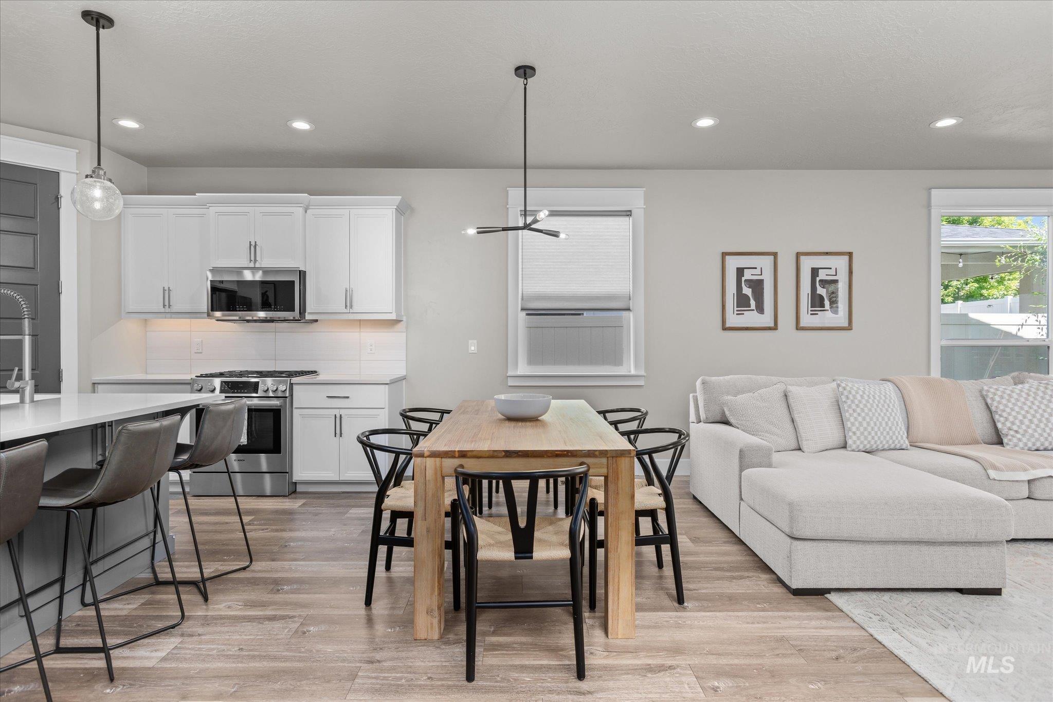 Dining room with recessed lighting, plenty of natural light, light wood-type flooring, and a chandelier