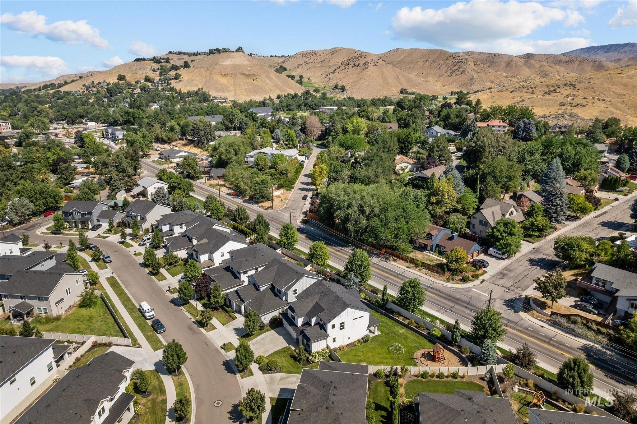 Aerial overview of property's location featuring mountains and nearby suburban area