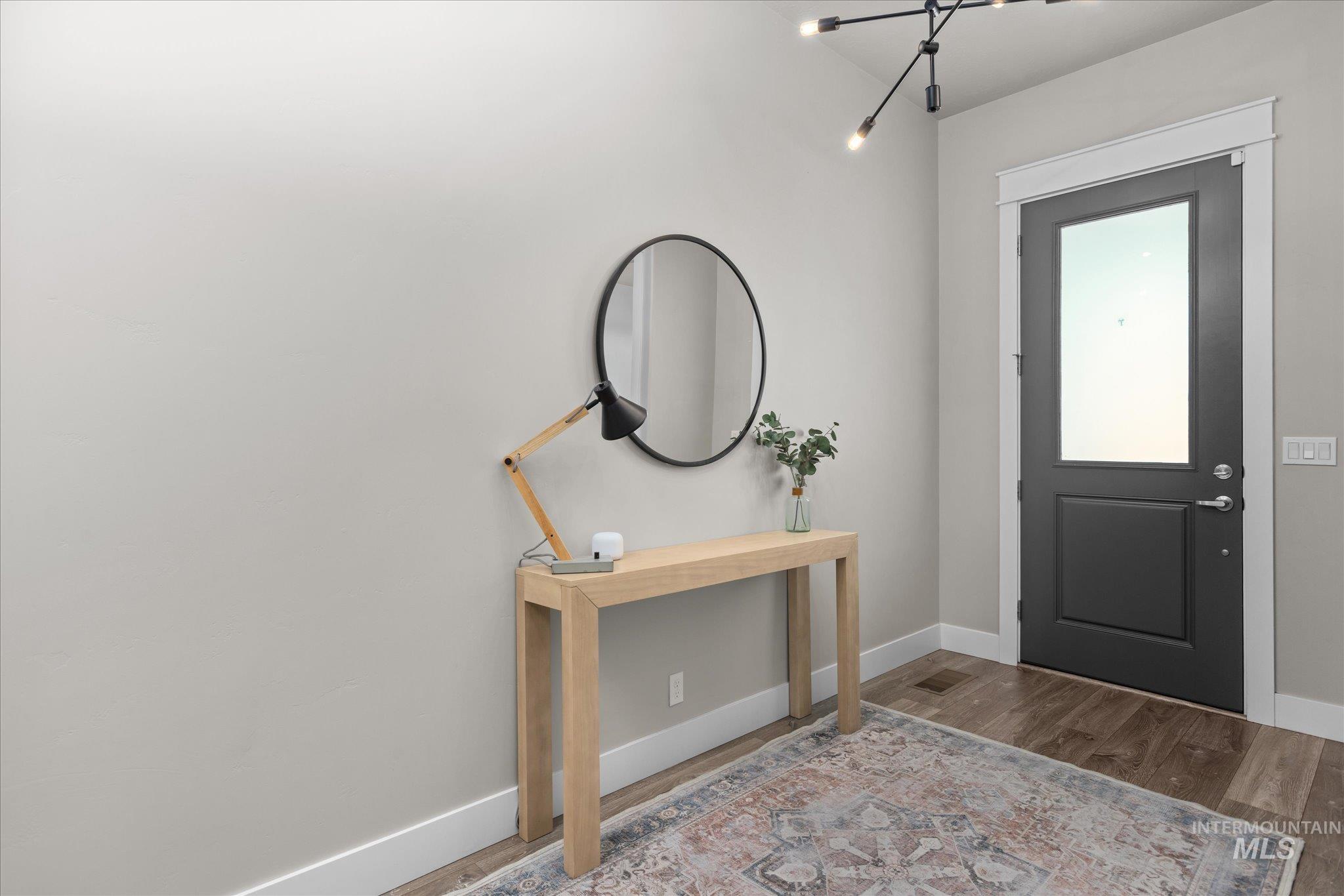 Entryway with wood finished floors and baseboards
