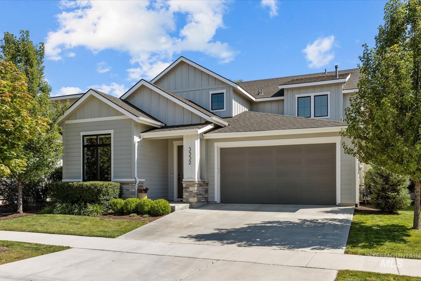 Craftsman house with roof with shingles, concrete driveway, board and batten siding, an attached garage, and stone siding