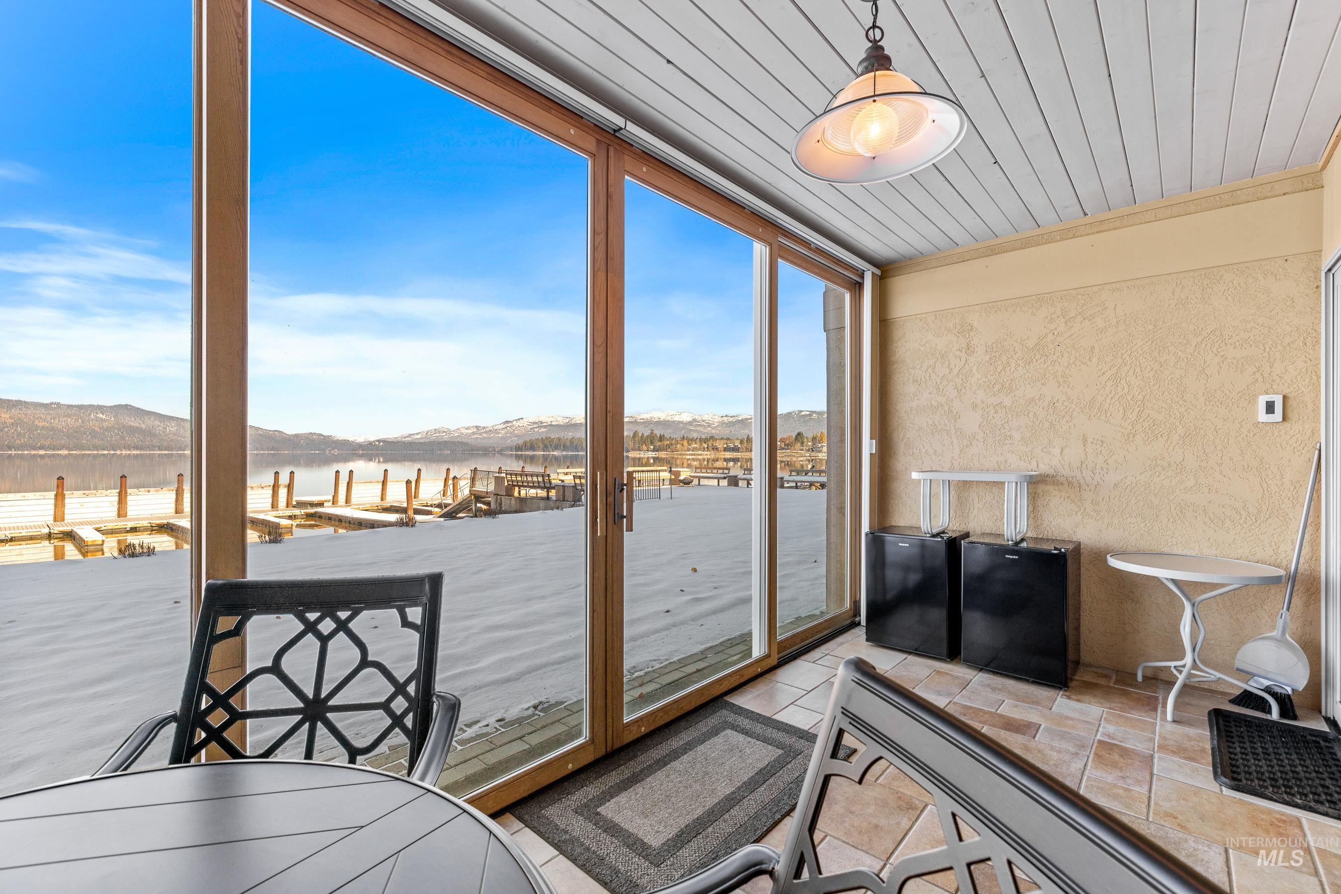 Sunroom featuring lake and mountain view, floor to ceiling windows just steps to the lake