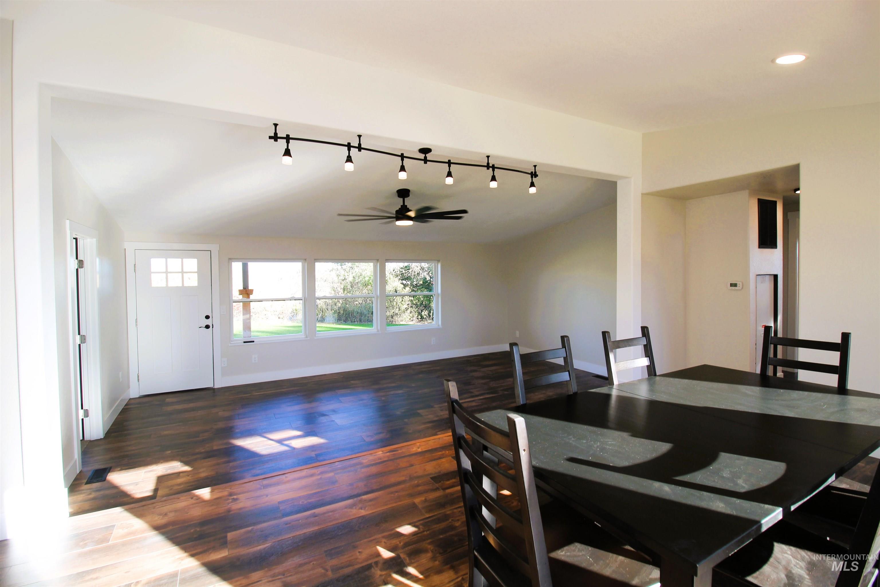 Dining space with ceiling fan, dark wood-style flooring, track lighting, and recessed lighting