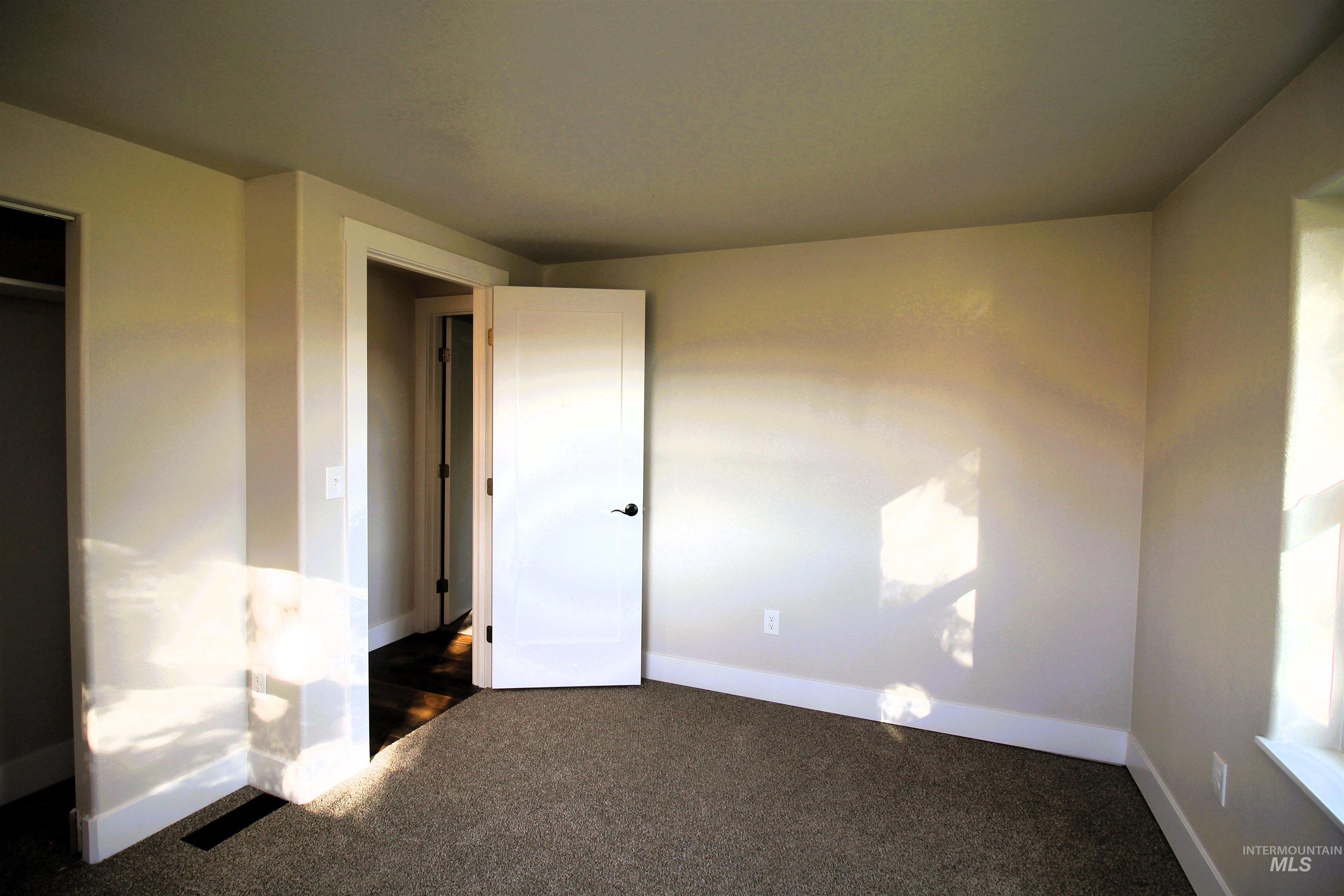 Unfurnished bedroom featuring baseboards and carpet floors