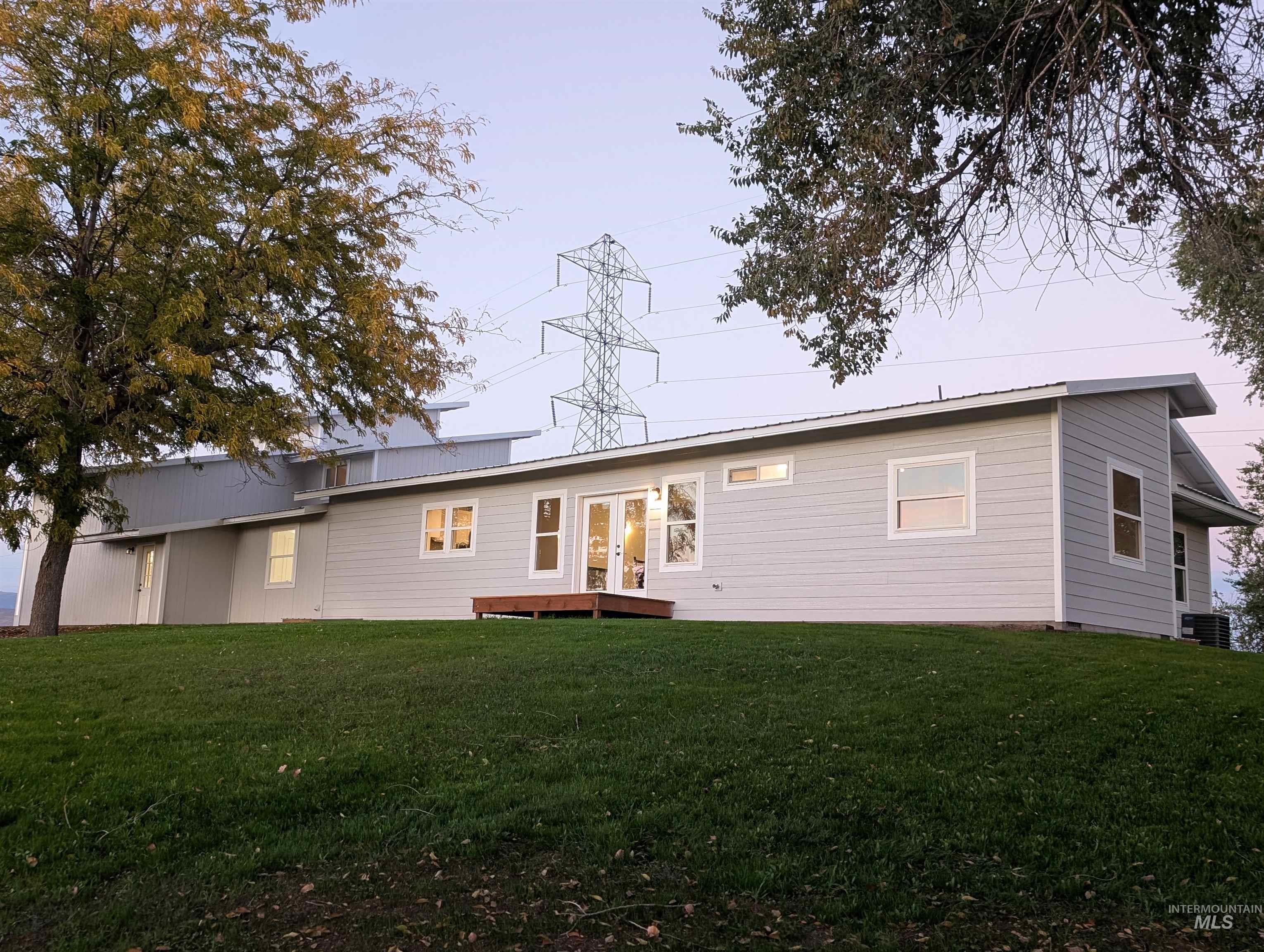 Rear view of house featuring a yard, a metal roof, and french doors