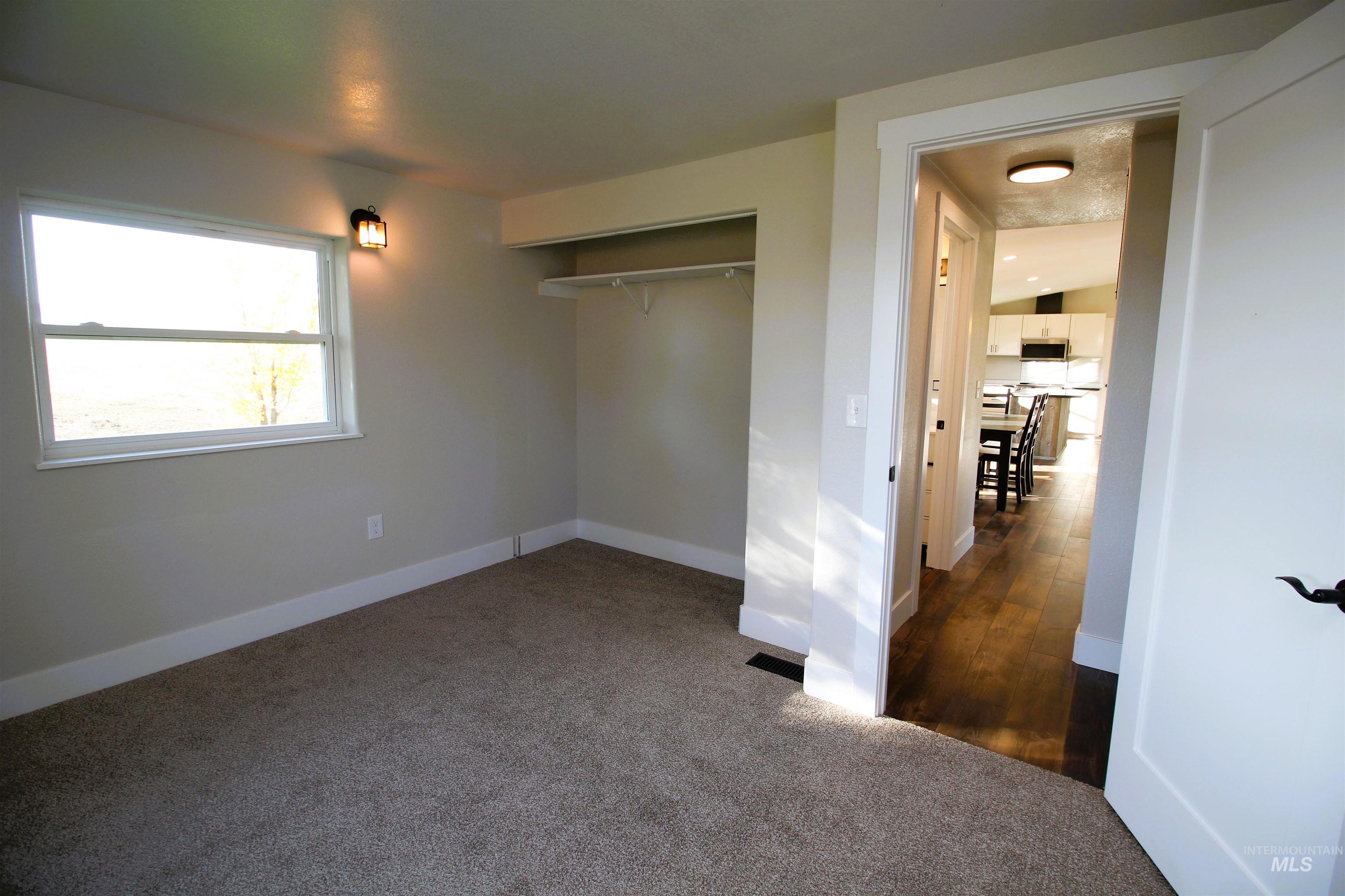 Unfurnished bedroom featuring dark carpet and a closet