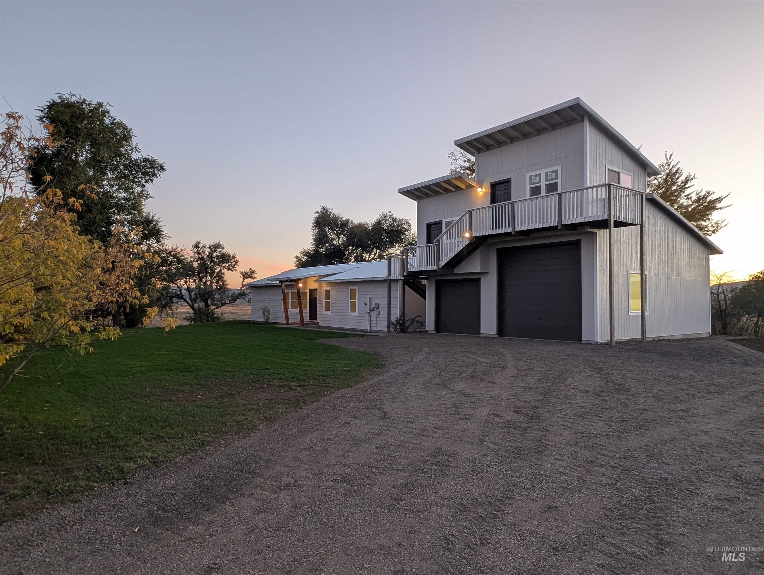 View of front of house with driveway, an attached garage, and a yard