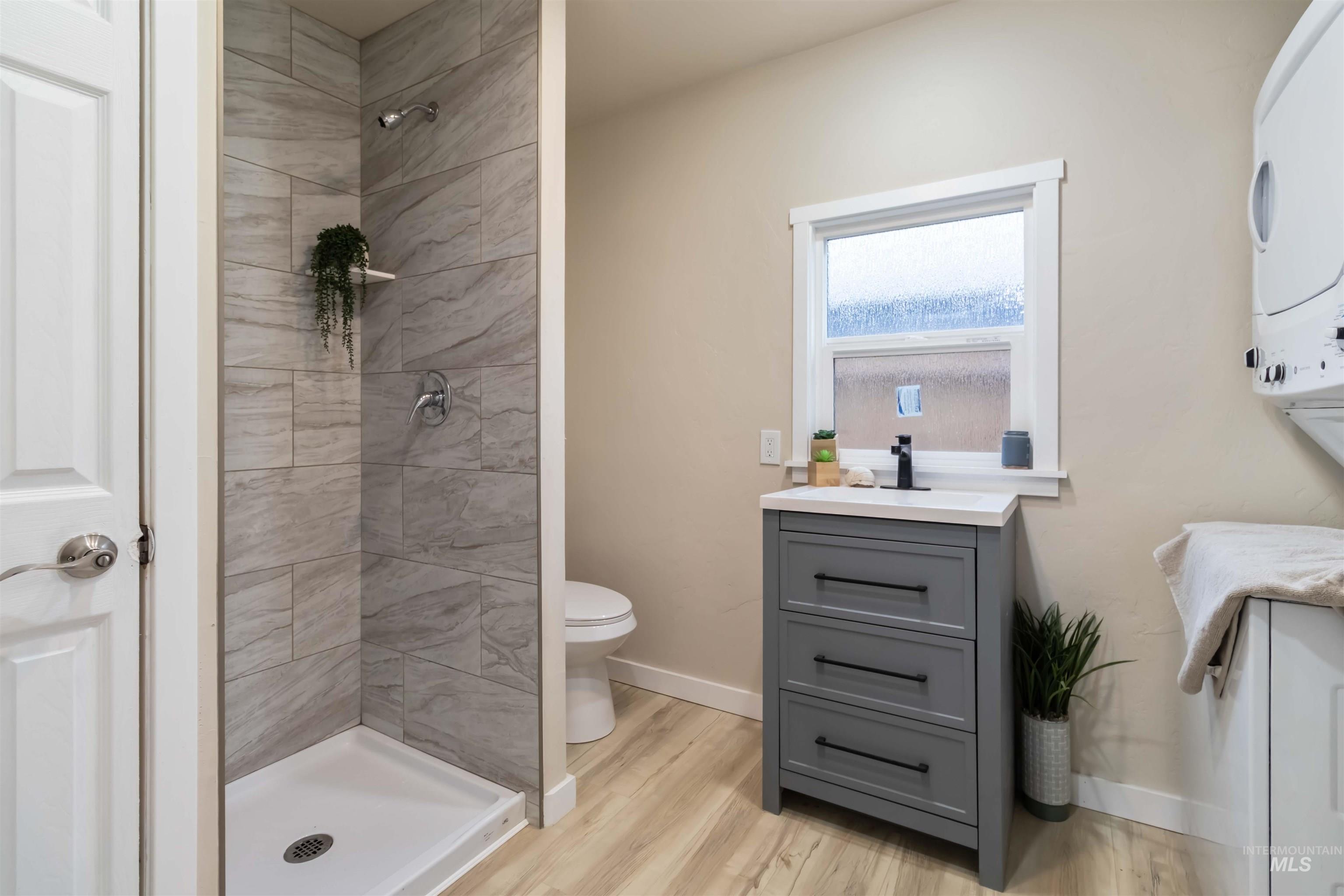 Bathroom with vanity, a stall shower, and light wood-style flooring