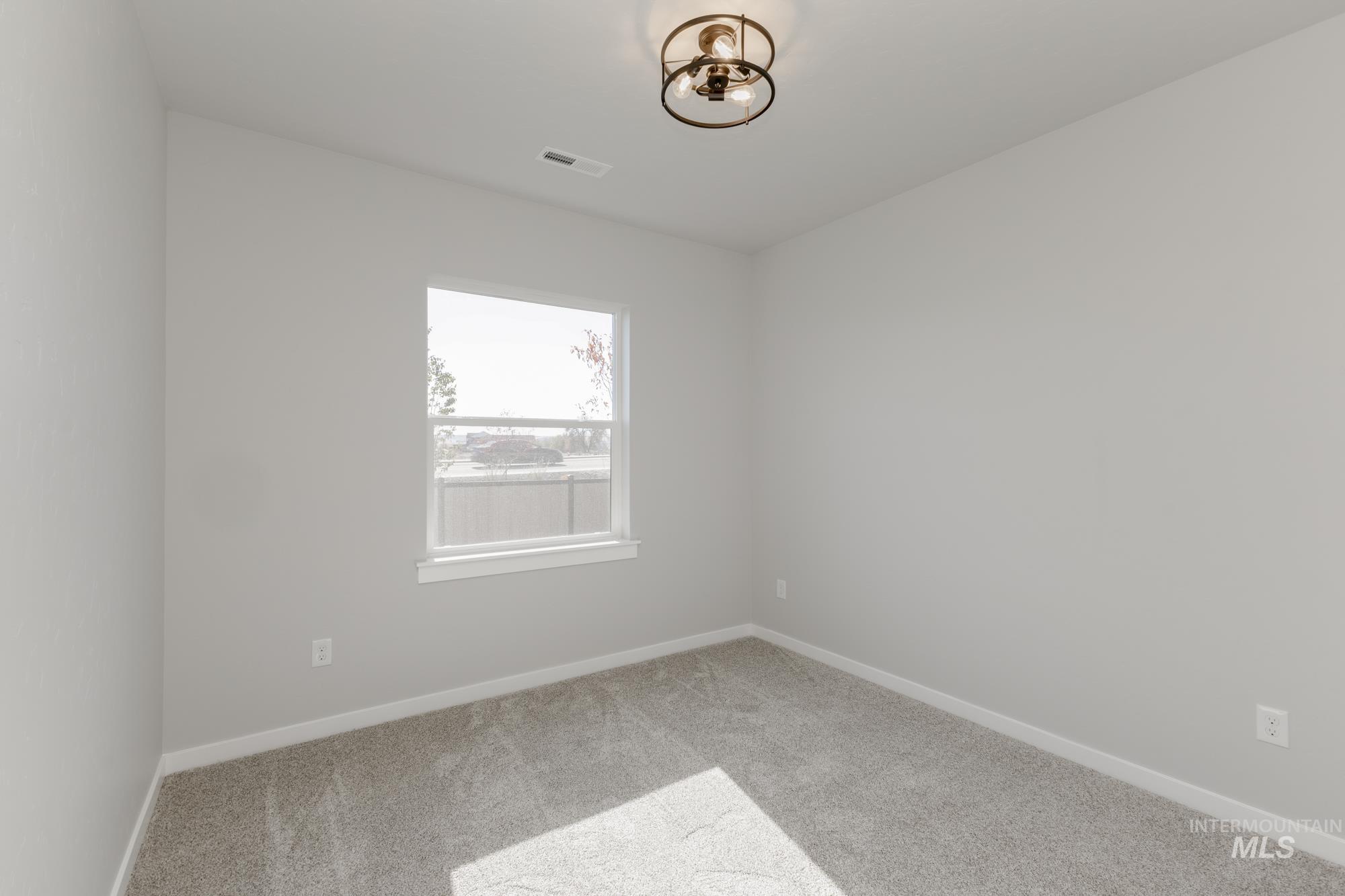 Spare room featuring baseboards and carpet floors