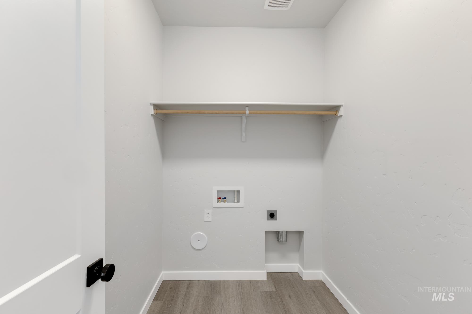 Laundry room featuring hookup for an electric dryer, light wood-style floors, and hookup for a washing machine