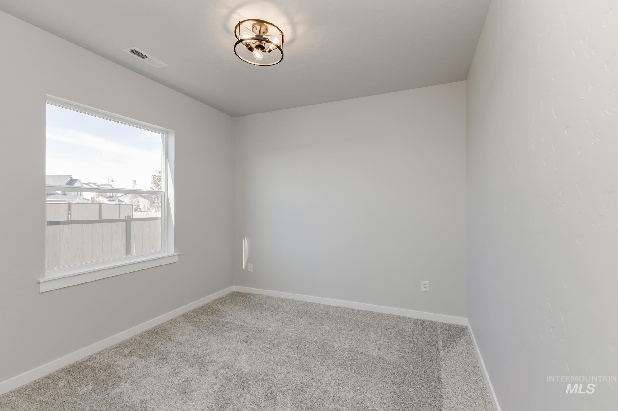 Carpeted spare room with baseboards