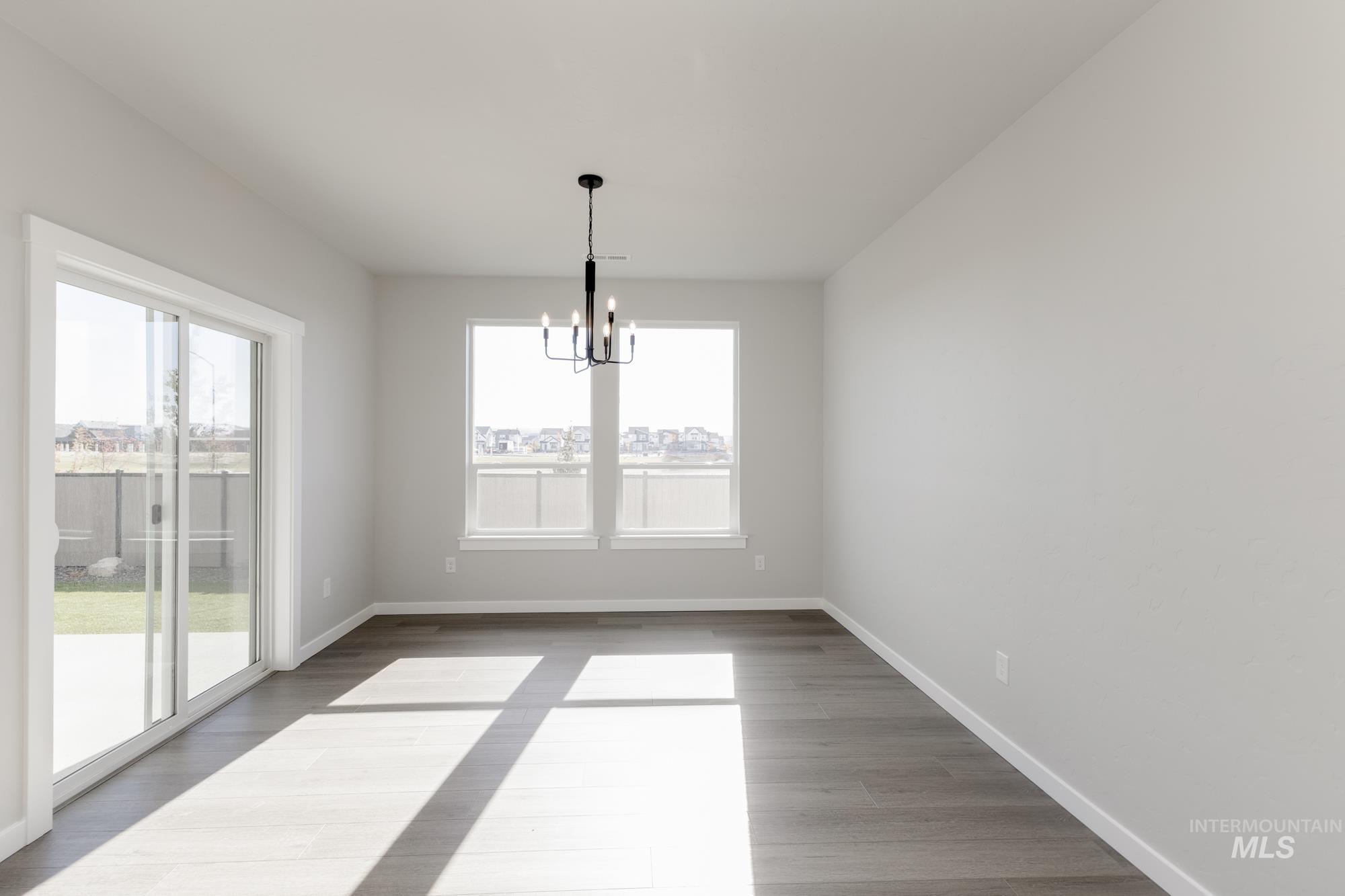 Unfurnished dining area featuring a chandelier and wood finished floors