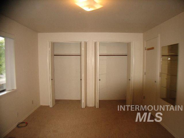 Unfurnished bedroom on north end featuring two closets and carpeted floors