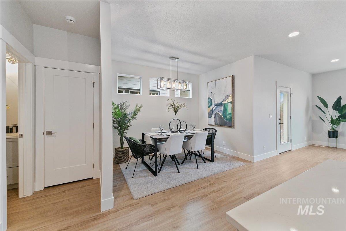 Dining space with light wood-style flooring, recessed lighting, and a textured ceiling