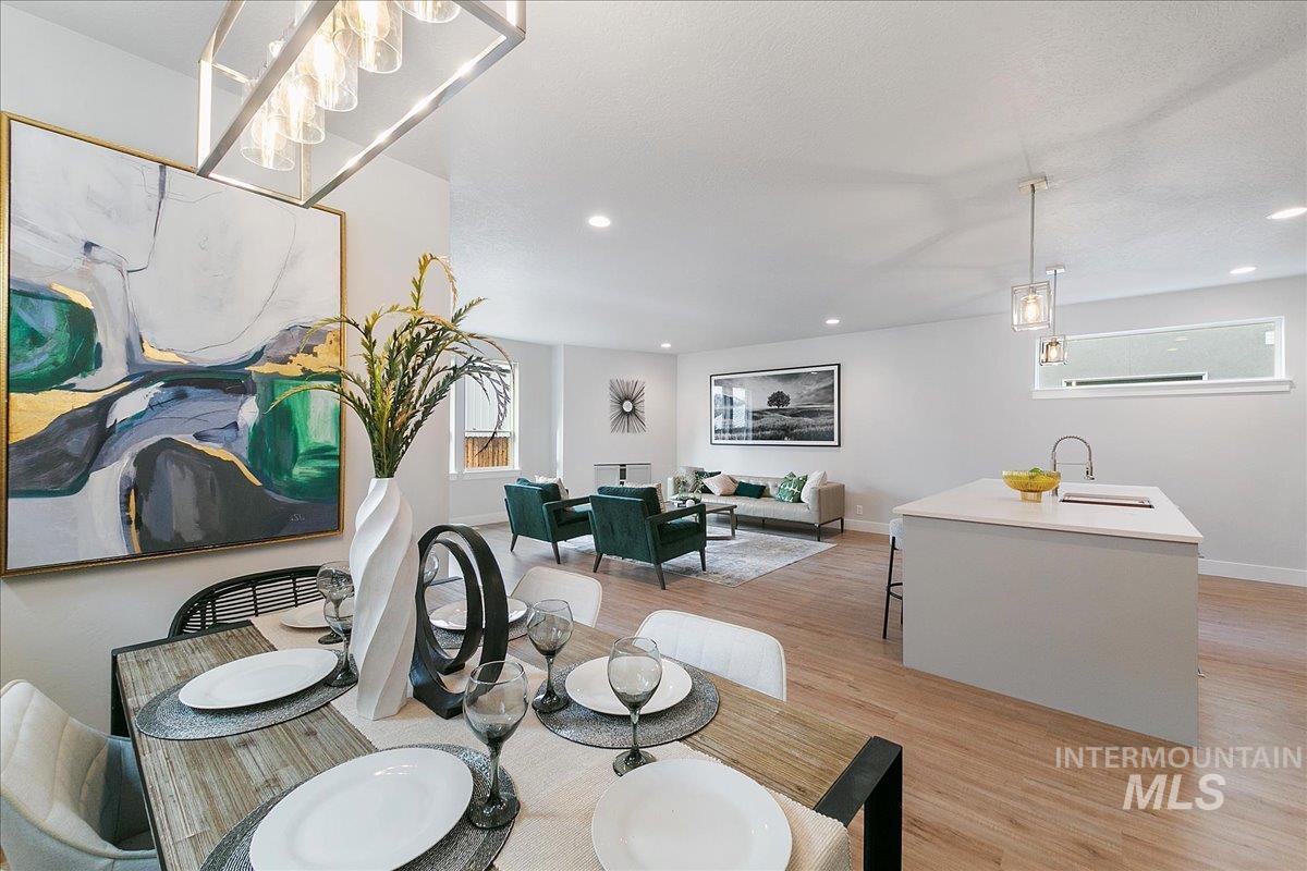 Dining area with light wood finished floors and recessed lighting