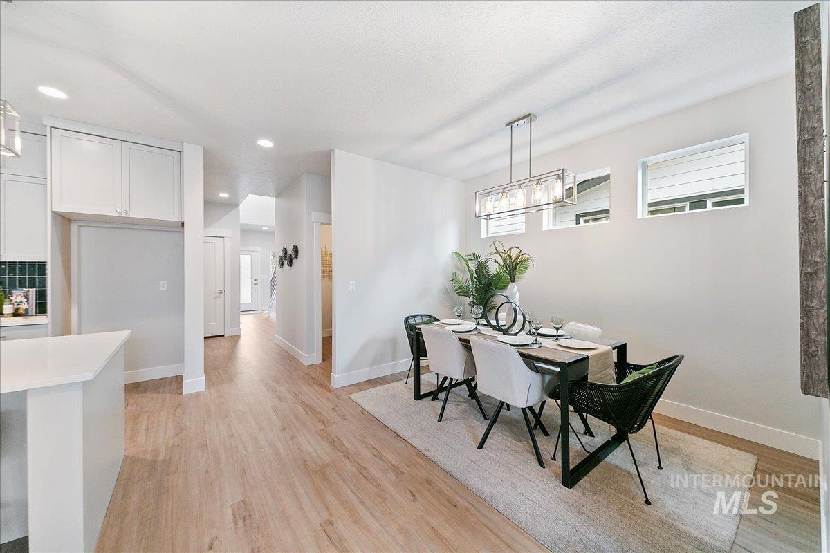Dining room with light wood-type flooring and recessed lighting