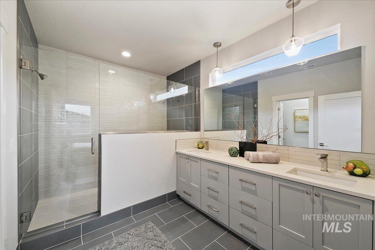 Bathroom with double vanity, a shower stall, dark tile patterned floors, tasteful backsplash, and recessed lighting
