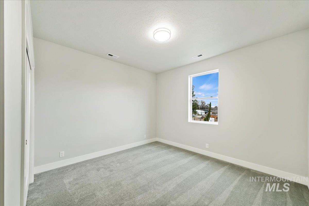 Spare room with carpet flooring and a textured ceiling