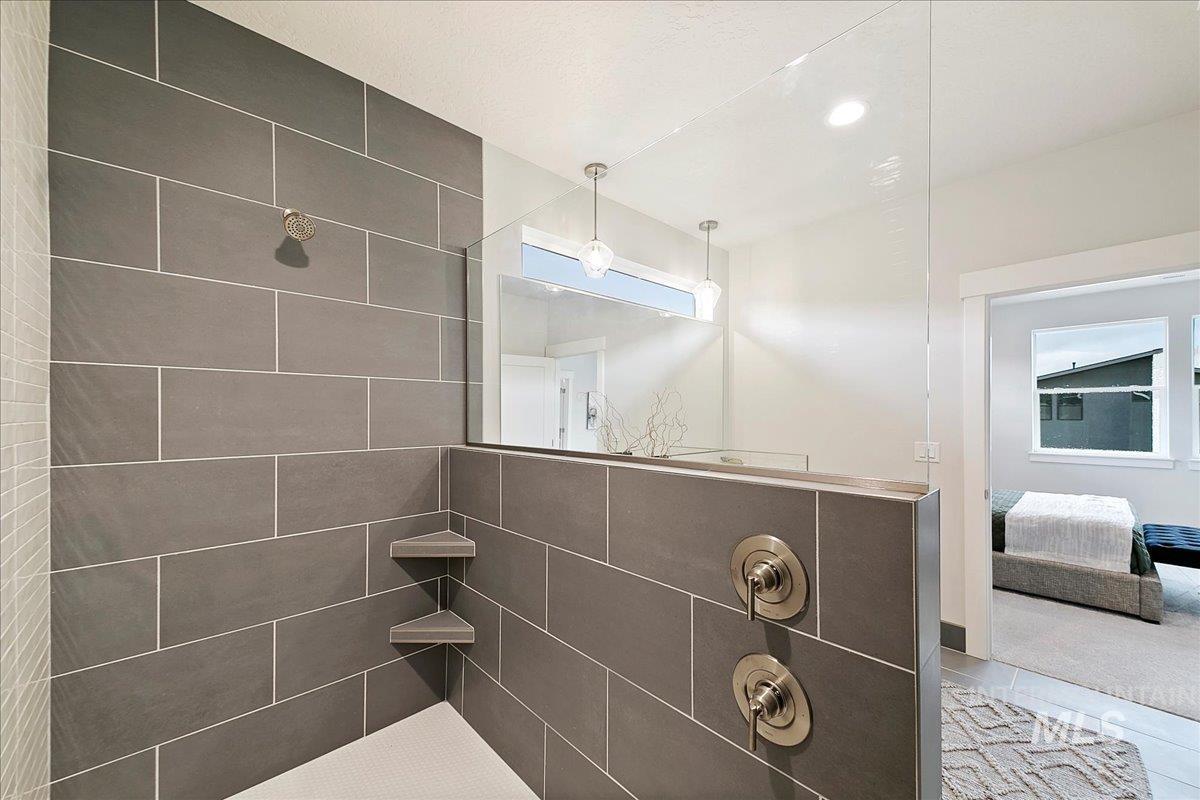 Ensuite bathroom with a tile shower, recessed lighting, and tile patterned floors