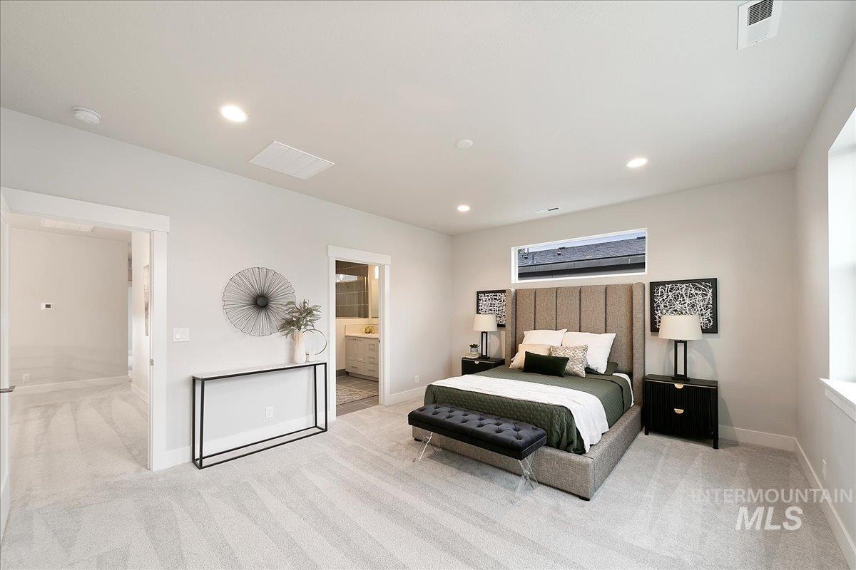 Bedroom featuring light carpet, recessed lighting, and connected bathroom