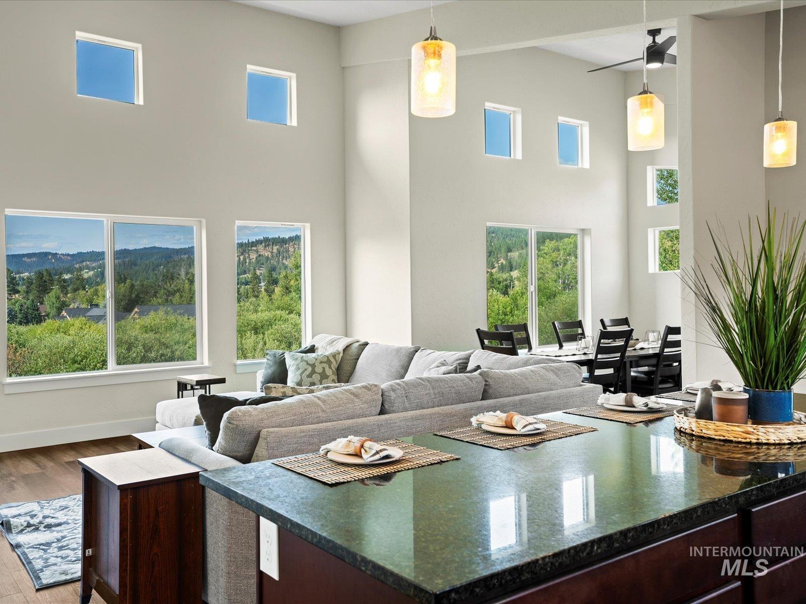 Living area featuring a towering ceiling, dark wood finished floors, and plenty of natural light