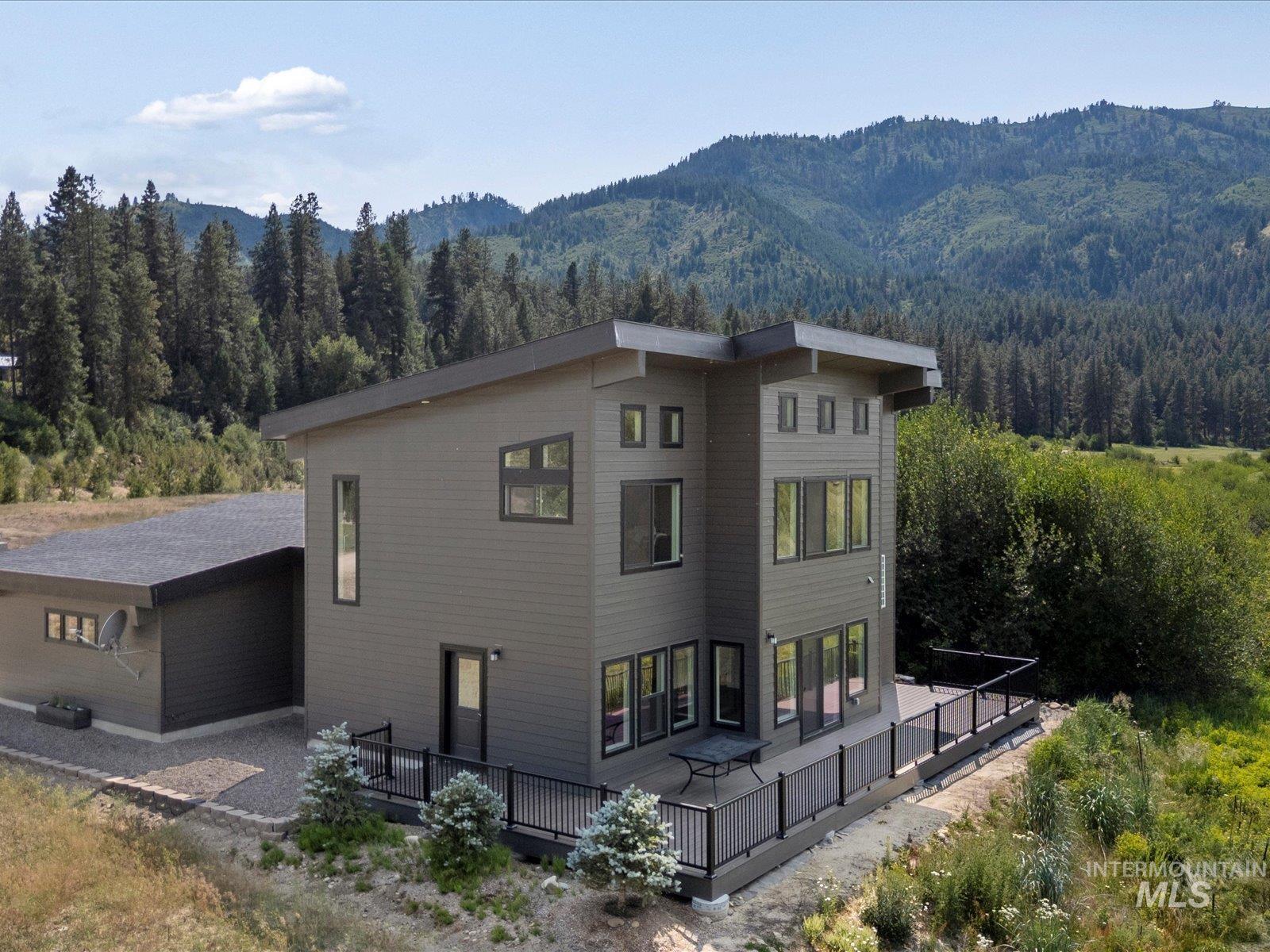 View of home's exterior featuring a wooded view and a deck with mountain view