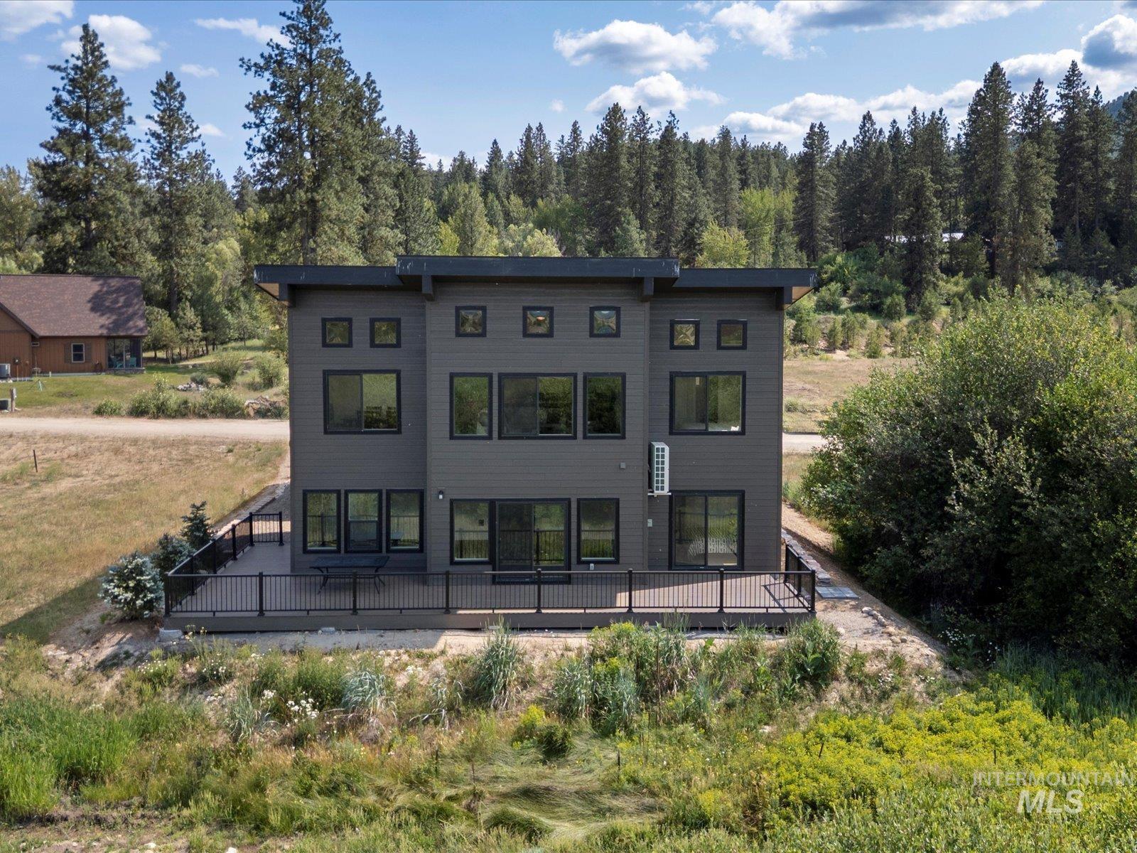 Rear view of property with a view of trees and a wooden deck