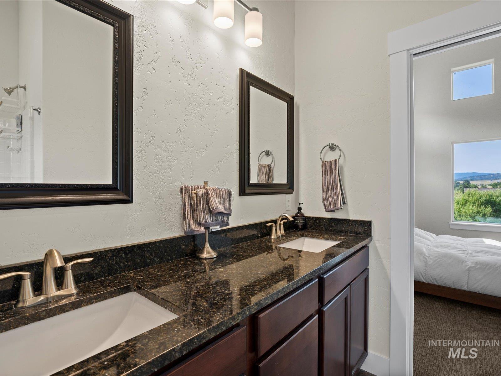 Bathroom featuring double vanity and ensuite bathroom