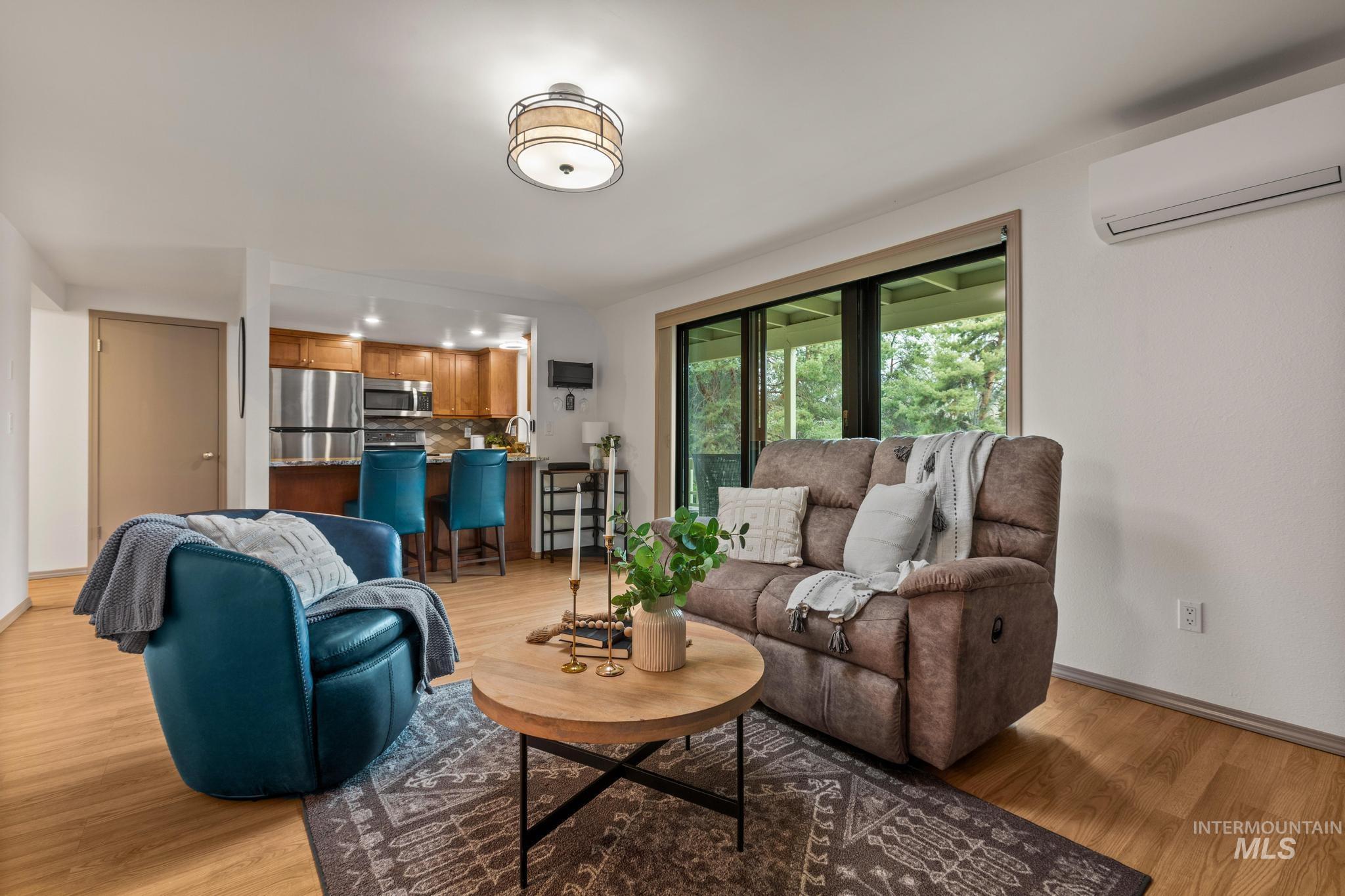 Living room with a mini split for heating / cooling and light wood-style flooring