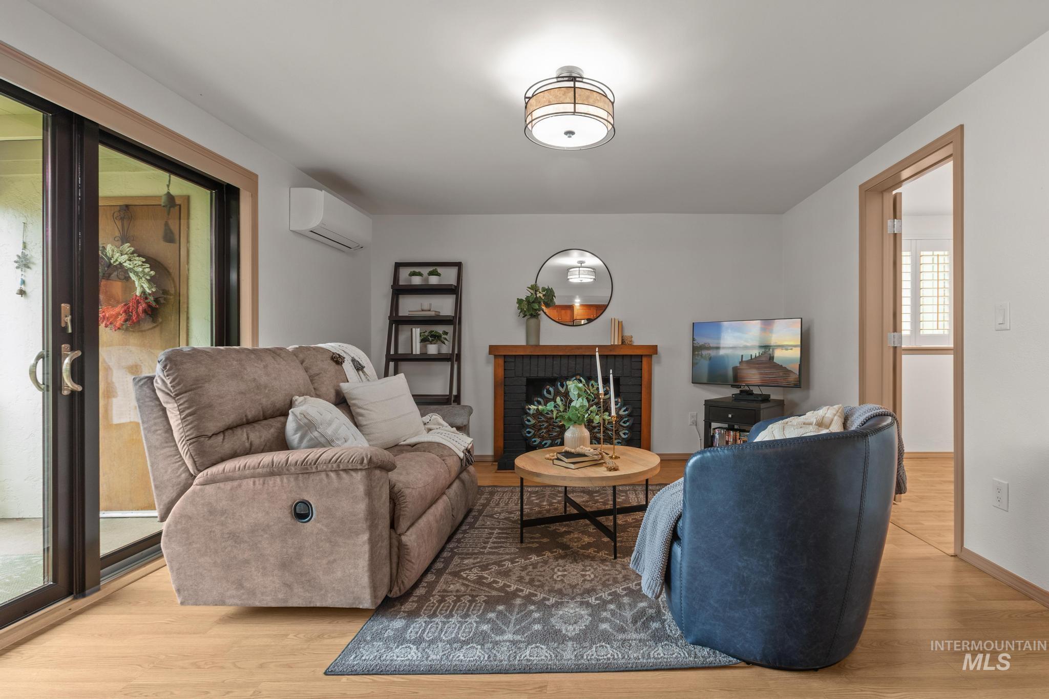Living area featuring a brick fireplace and light wood-style floors