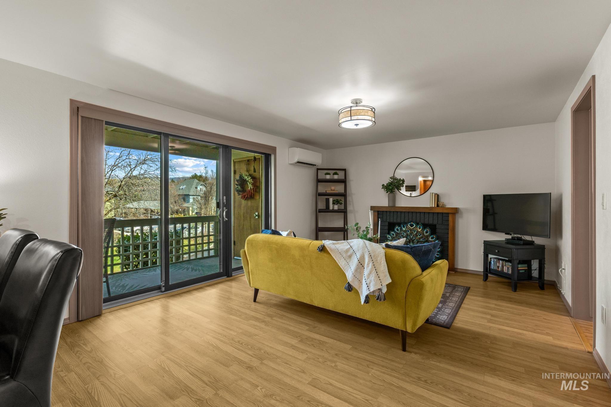 Living room featuring wood finished floors and a brick fireplace