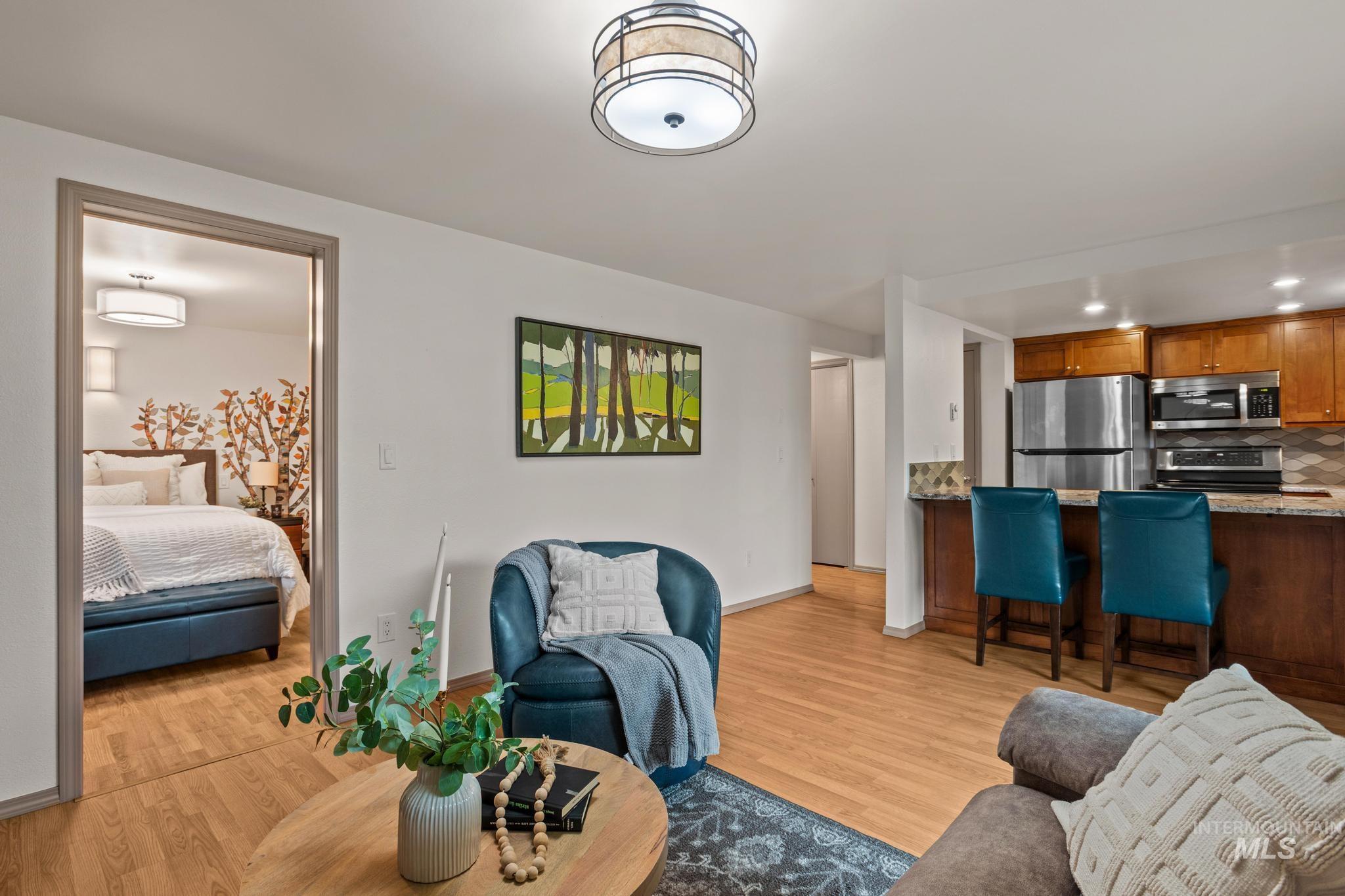 Living area with light wood finished floors and recessed lighting