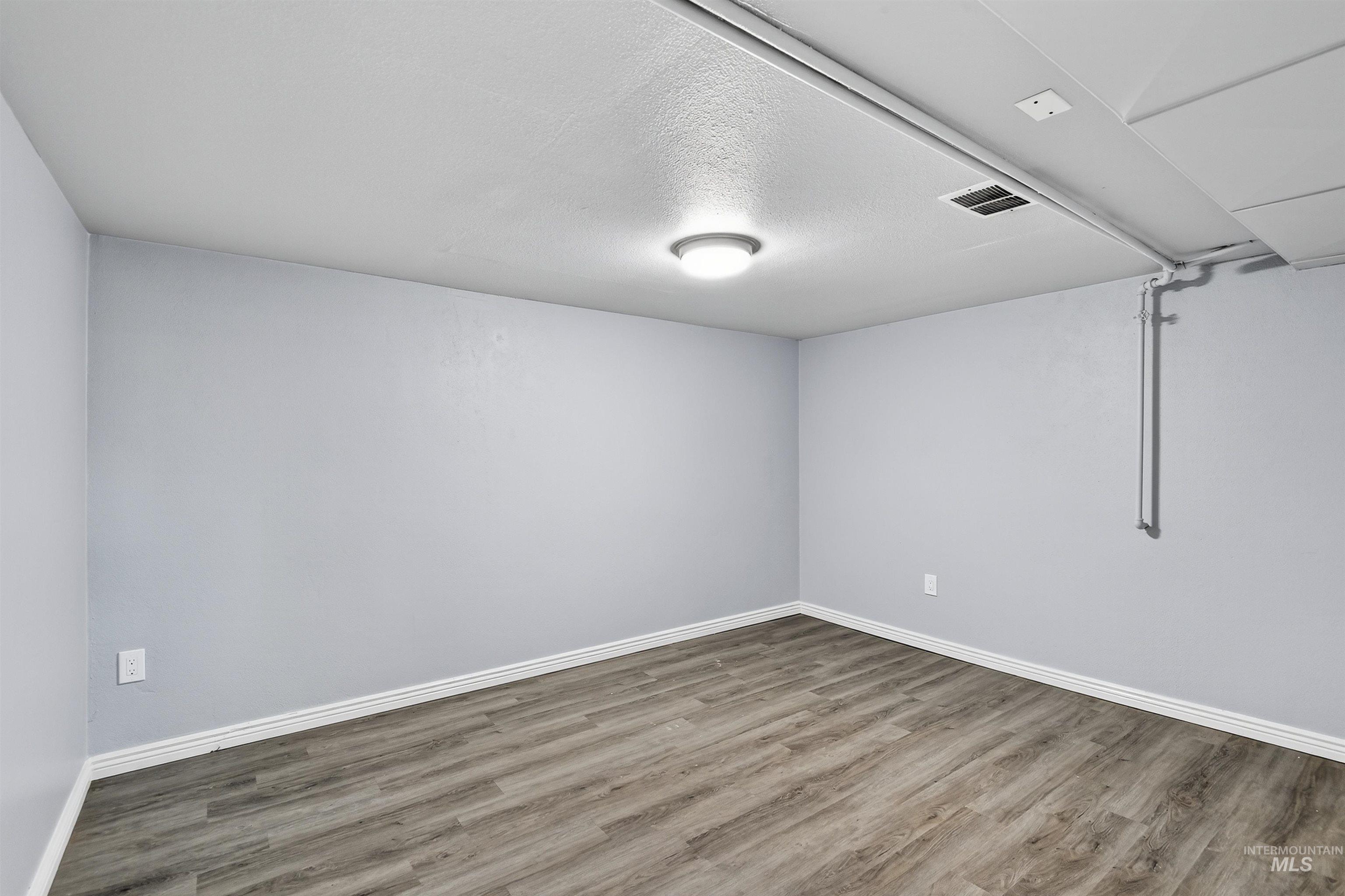 Unfurnished room with wood finished floors and a textured ceiling