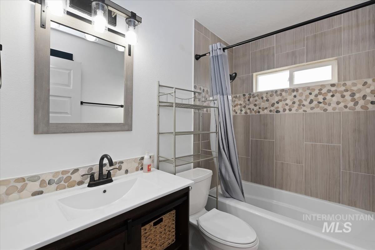 Full bathroom featuring vanity and shower / bathtub combination with curtain