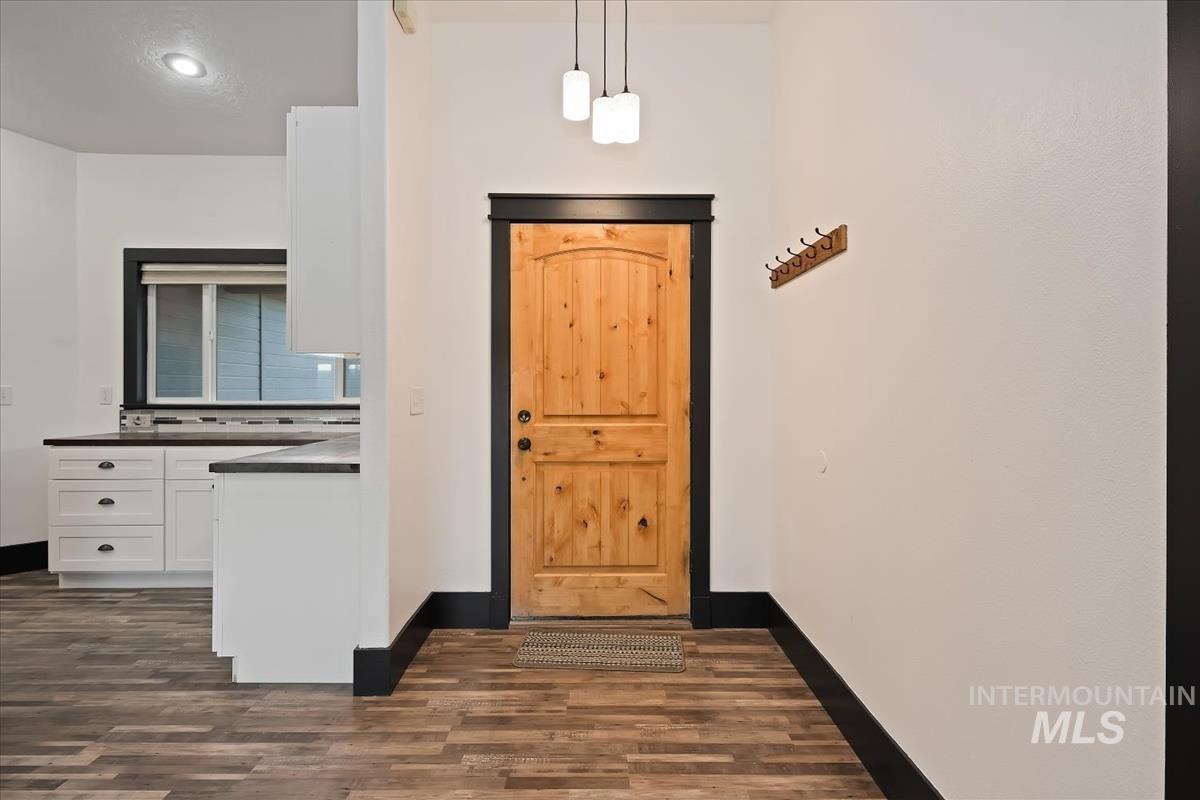 Foyer entrance featuring dark wood-style floors and baseboards