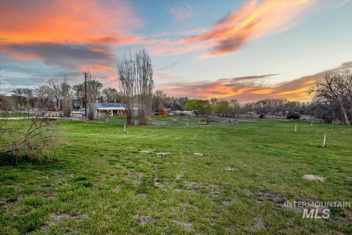 Yard at dusk featuring a lawn and a view of countryside