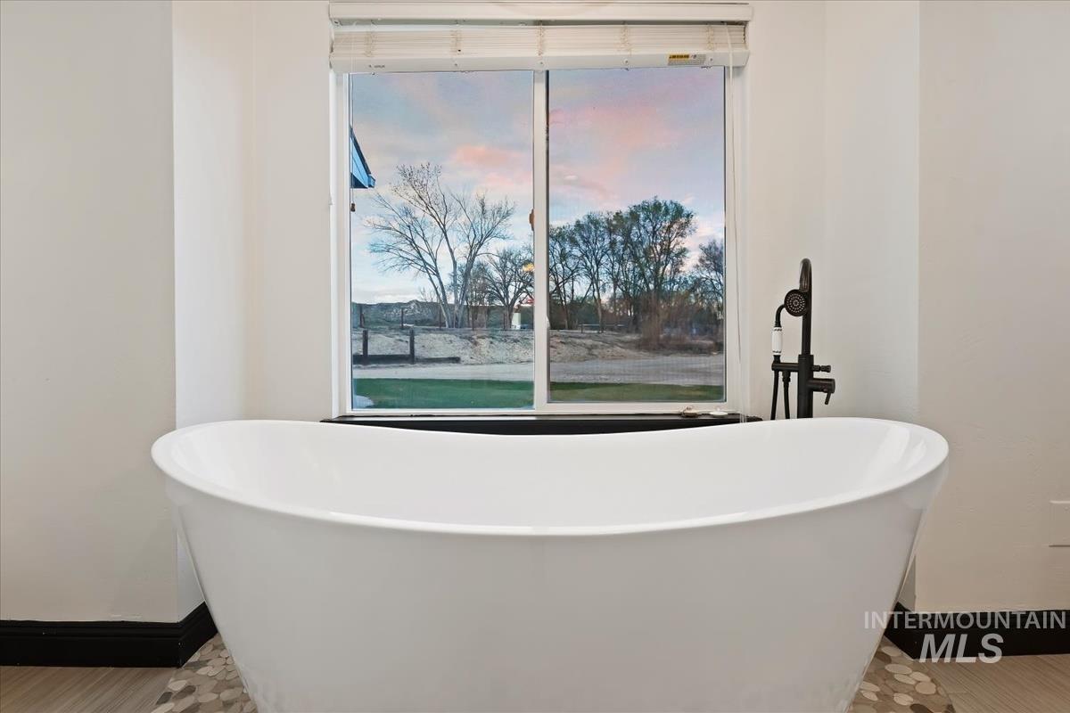 Bathroom featuring baseboards and a freestanding bath