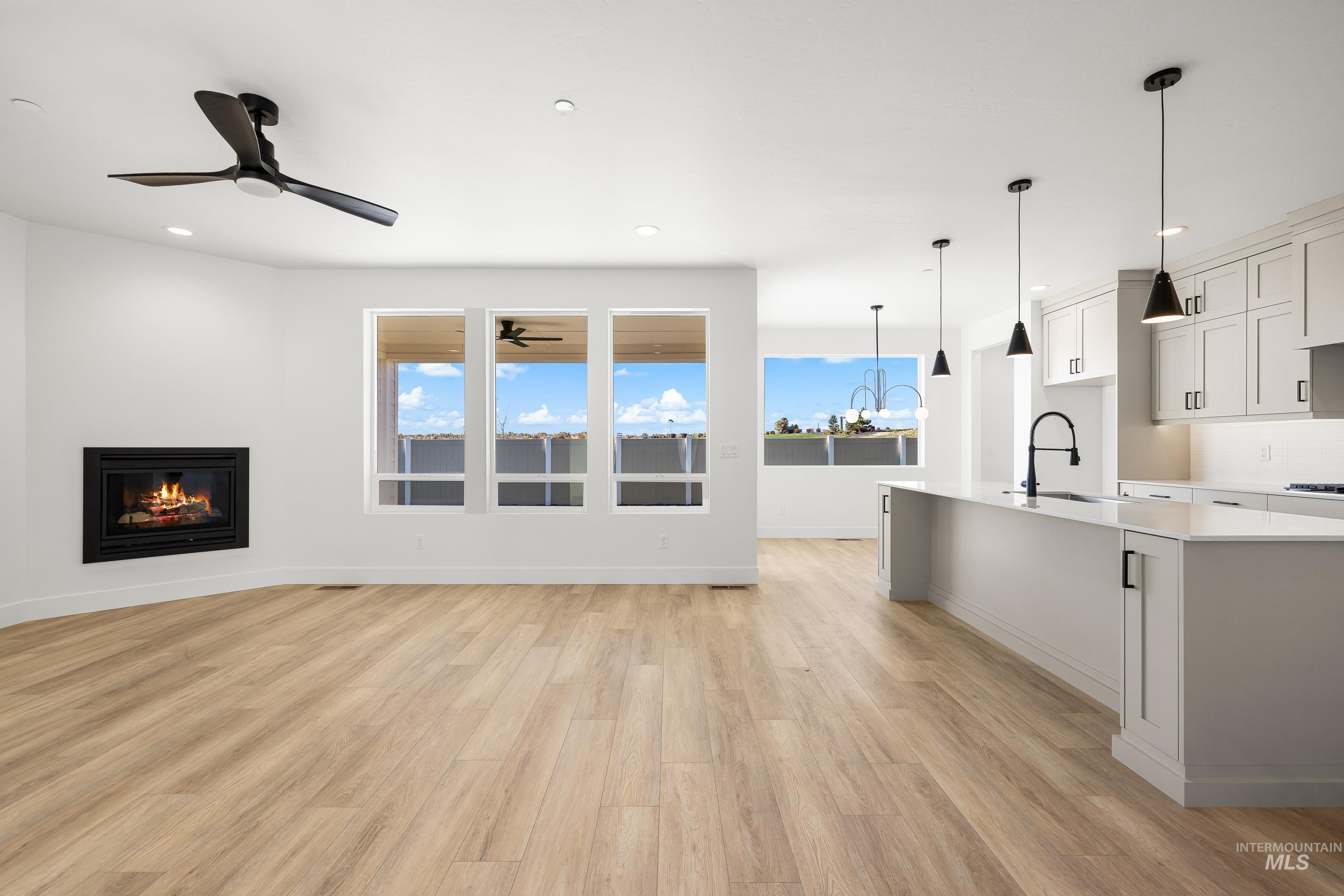 Unfurnished living room featuring a glass covered fireplace, light wood-style flooring, and recessed lighting