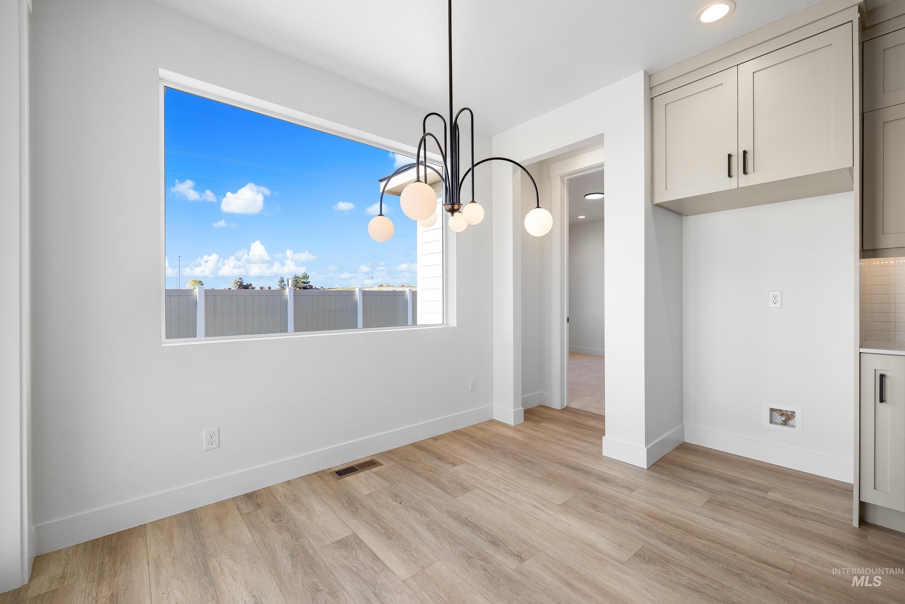 Unfurnished dining area featuring a chandelier, light wood-type flooring, and recessed lighting
