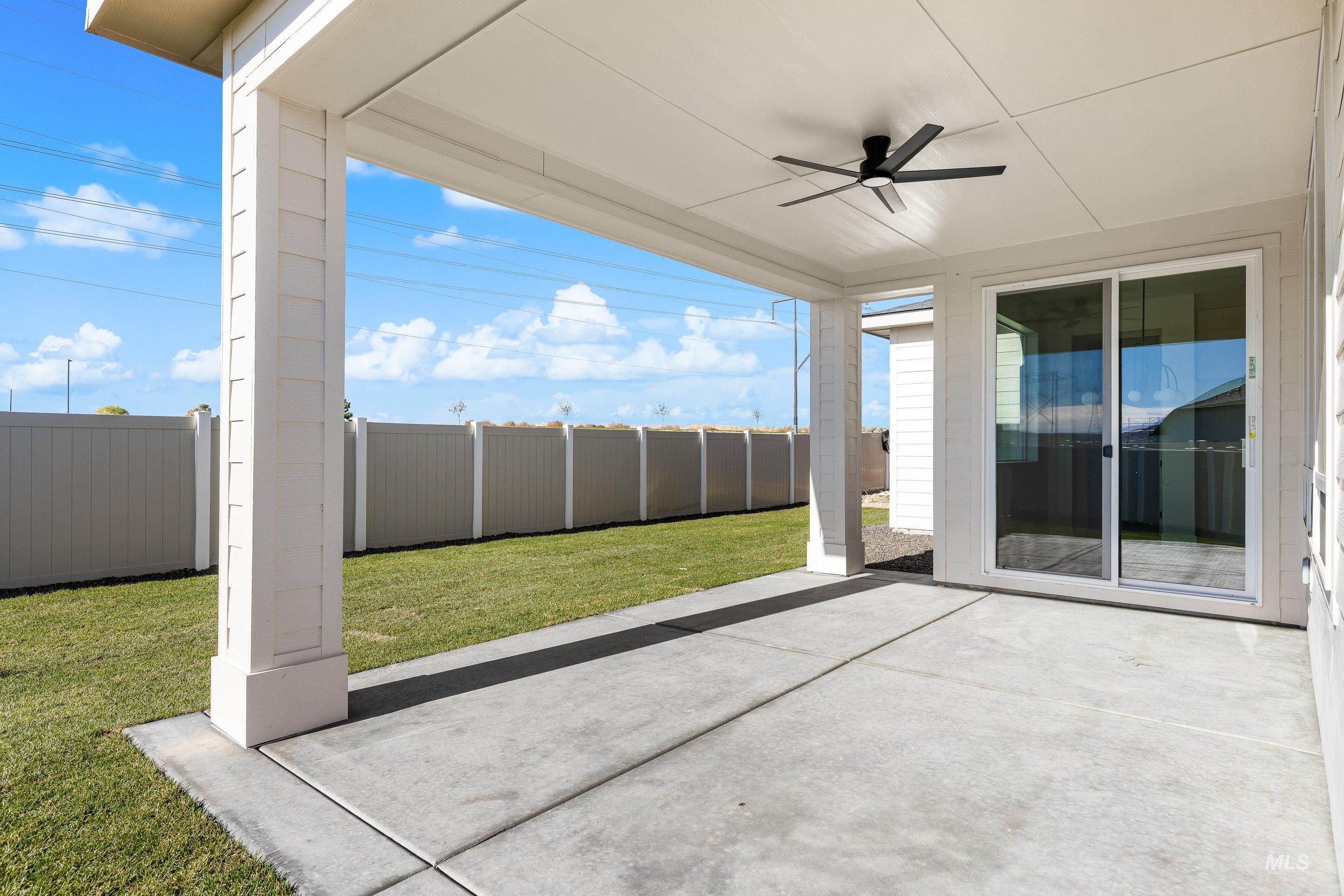 Fenced backyard with a patio area and a ceiling fan