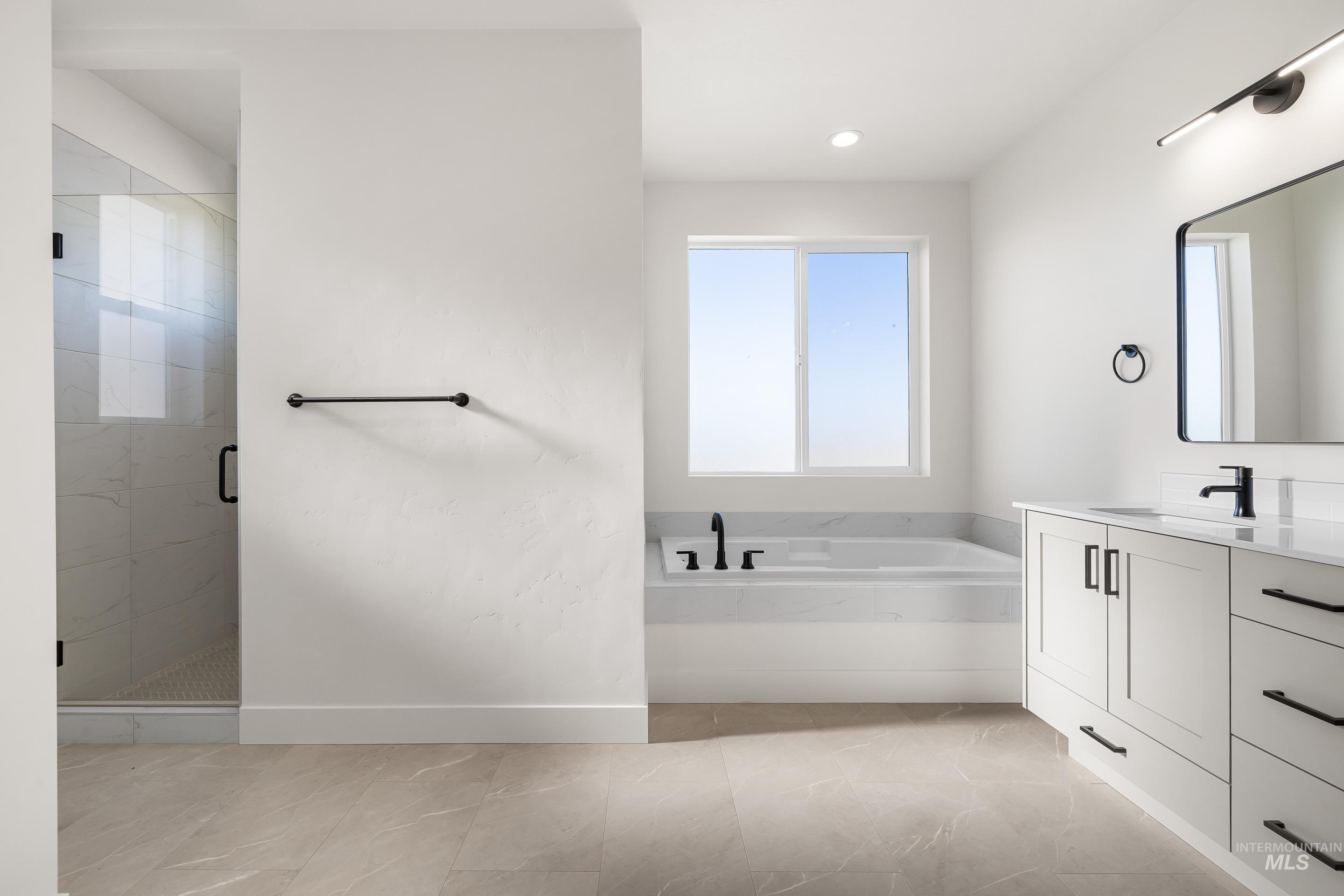 Full bath featuring vanity, a stall shower, a bath, and recessed lighting