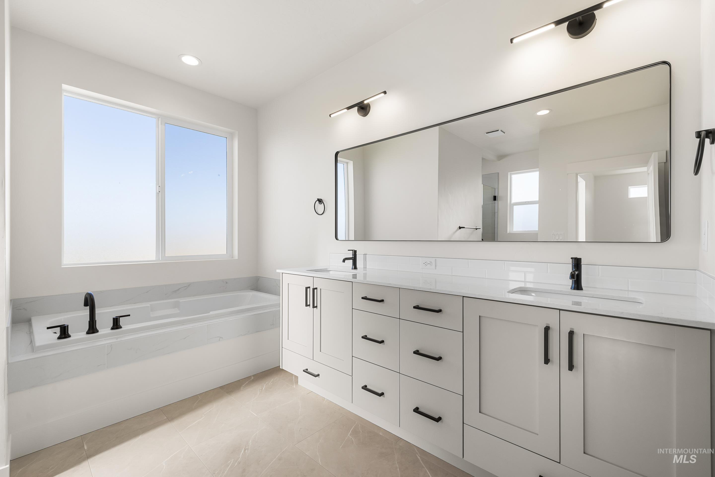 Full bathroom with double vanity, a bath, recessed lighting, light tile patterned floors, and walk in shower