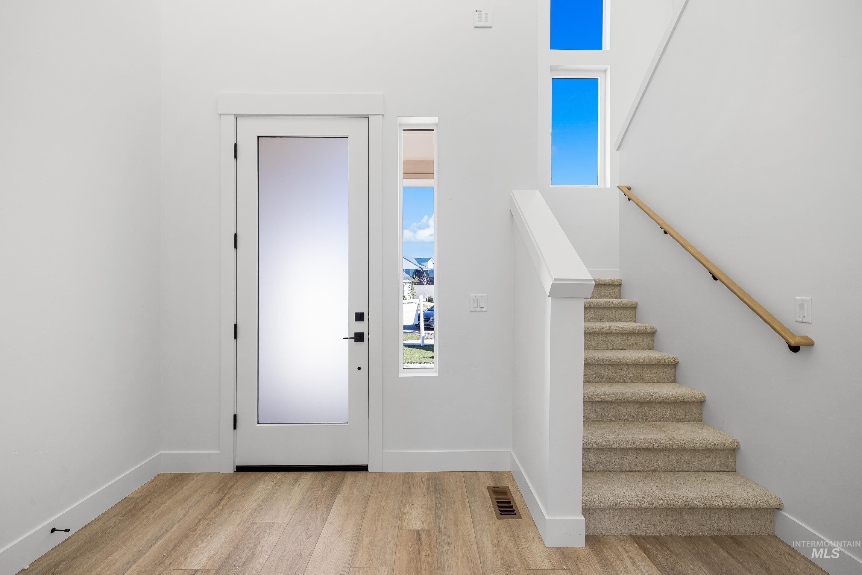 Foyer with light wood-style floors and stairway