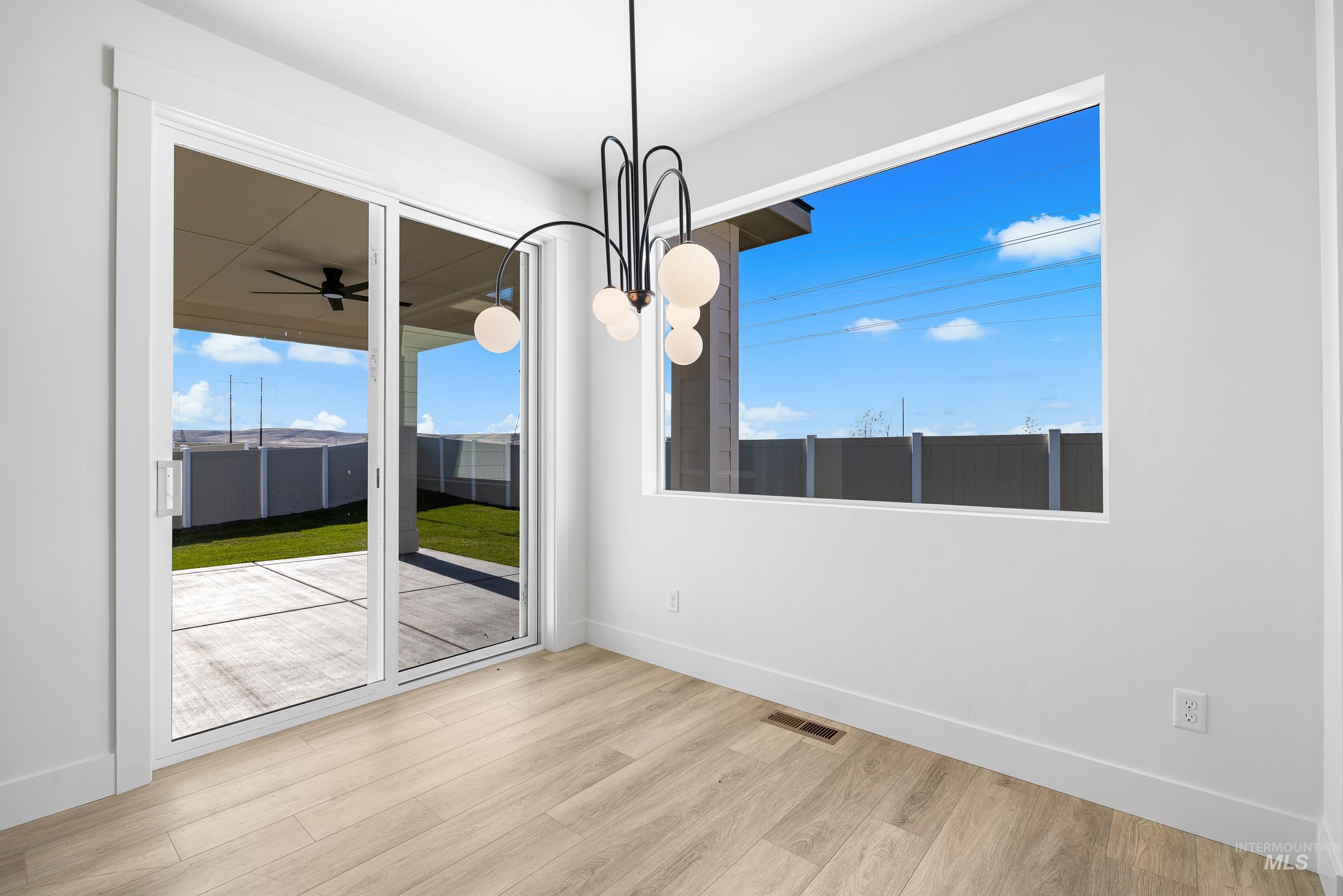Unfurnished dining area with plenty of natural light, light wood-style flooring, a sunroom, and ceiling fan