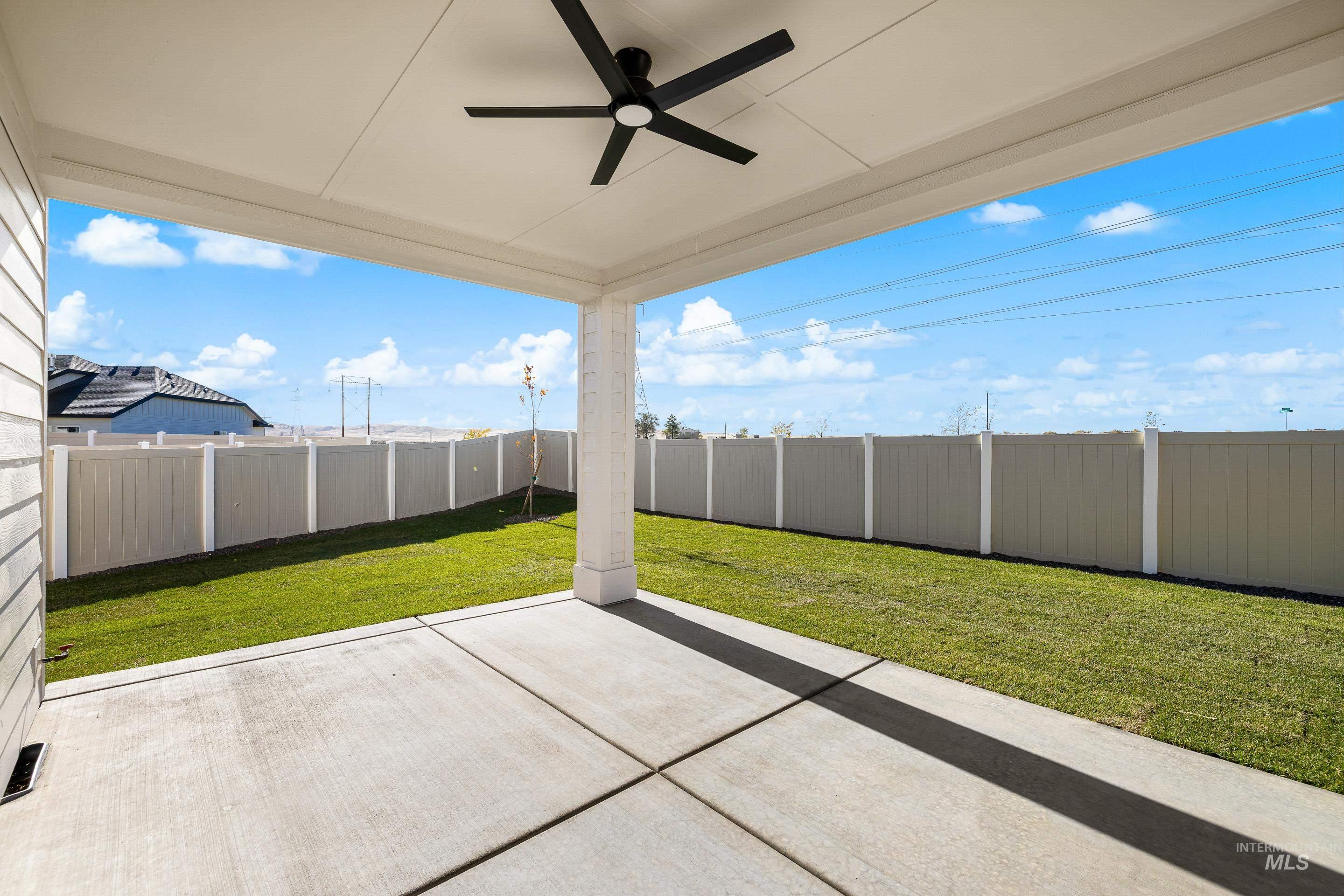 Fenced backyard with a patio and a ceiling fan